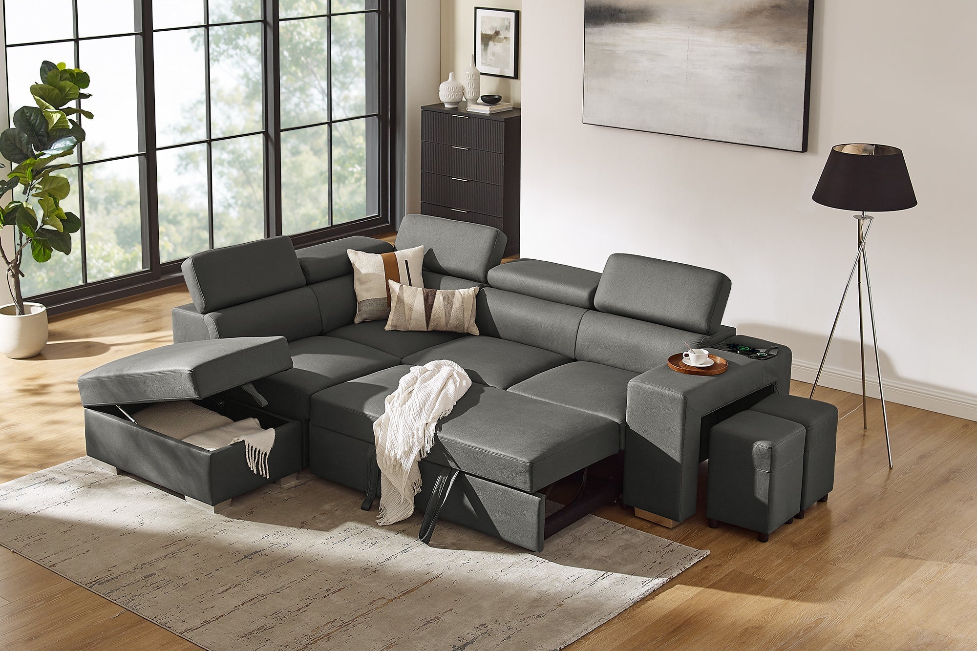 Modern grey sectional sofa with storage, chaise, and ottomans in a bright living room