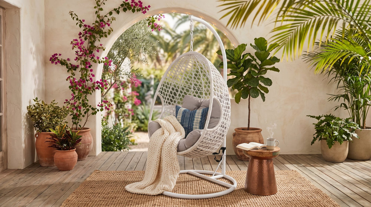Jimmy outdoor egg pod chair with a white woven shell and stand on a patio with plants