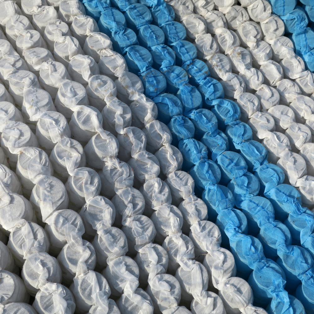 Close-up of white and blue pocket springs in a zone support mattress core