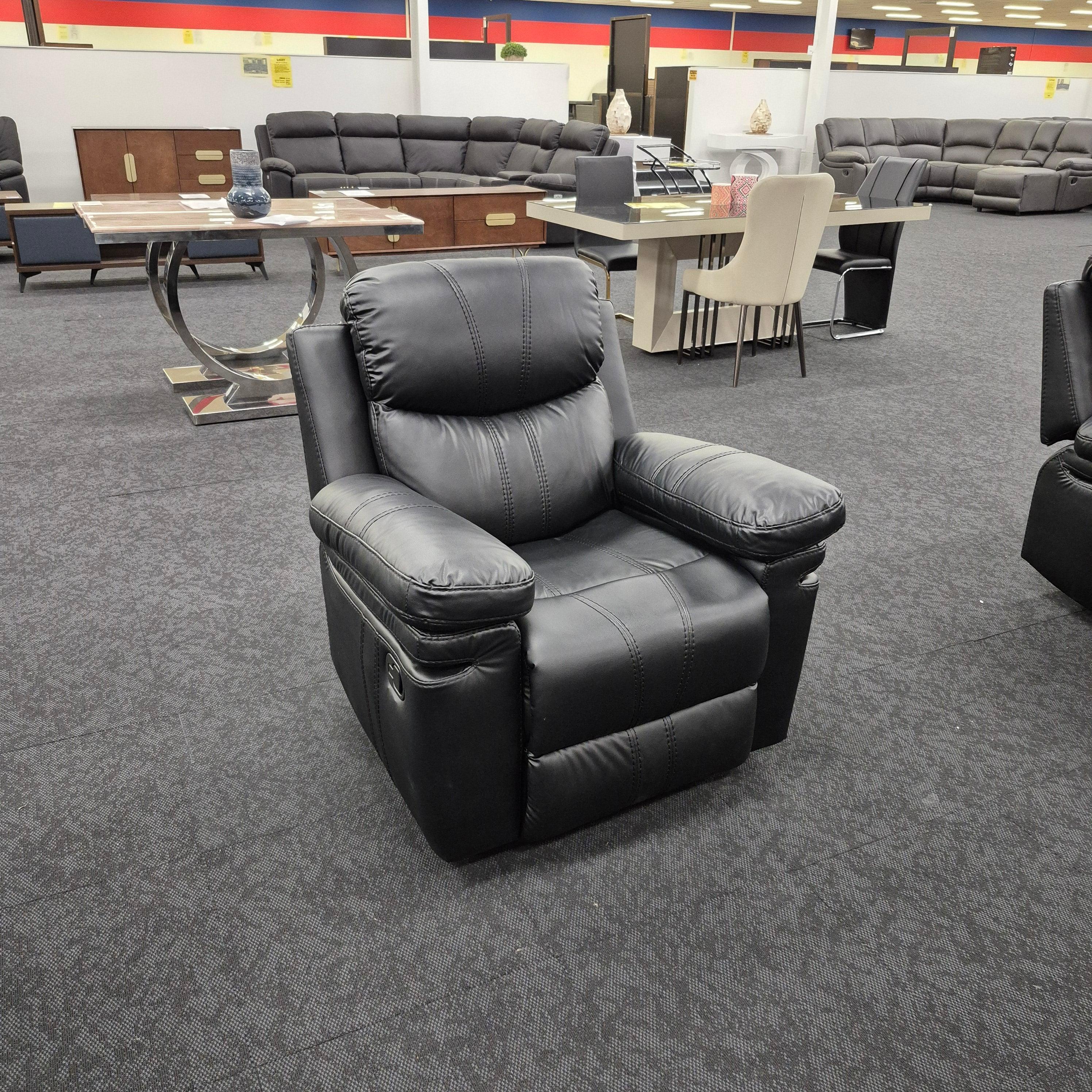 Black leather recliner armchair in a furniture showroom with sofas and dining tables
