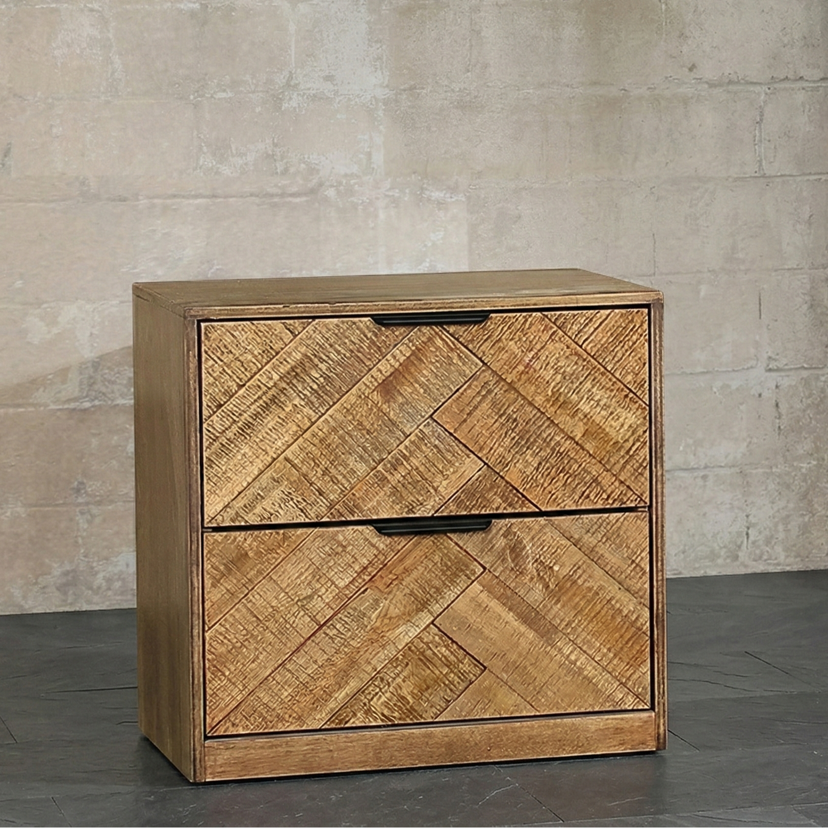 Wooden bed side table with herringbone pattern against a stone. wall.