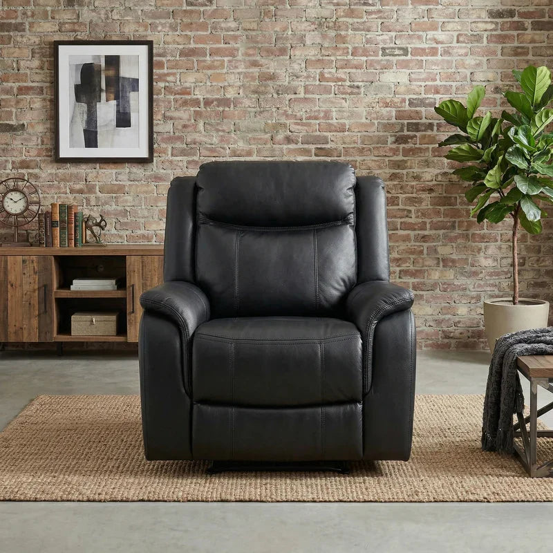 Sunshine Rocker & Swivel Recliner Chair in black leather placed in a stylish living room with a brick wall, wooden sideboard, framed abstract art, and green potted plant.