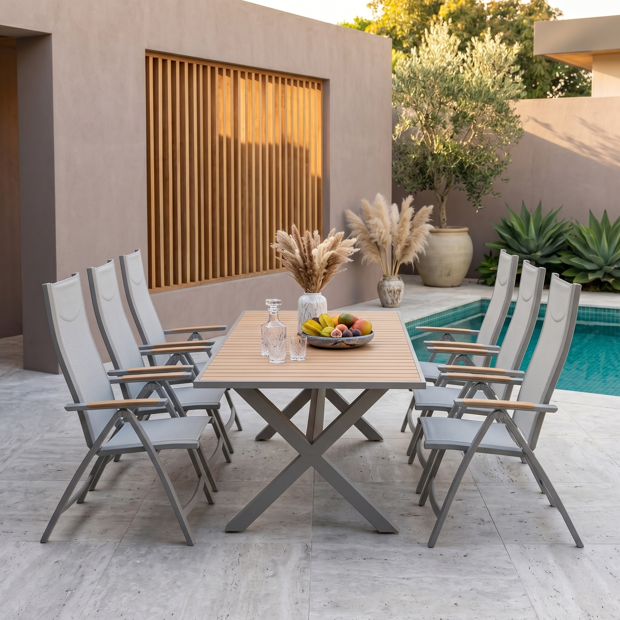 Outdoor patio set with table and chairs near a pool