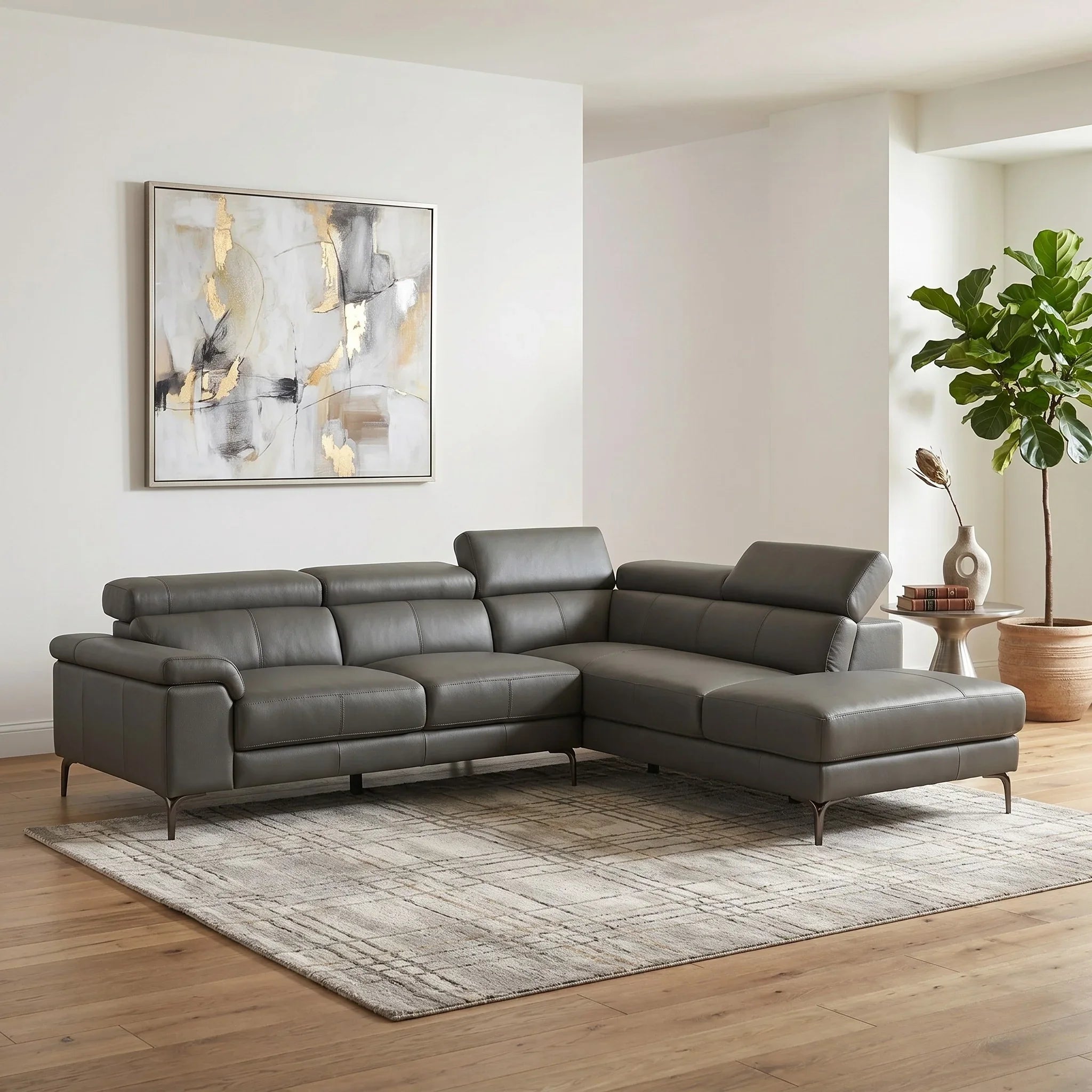 Anthracite sectional sofa in a living room with abstract art and a plant.