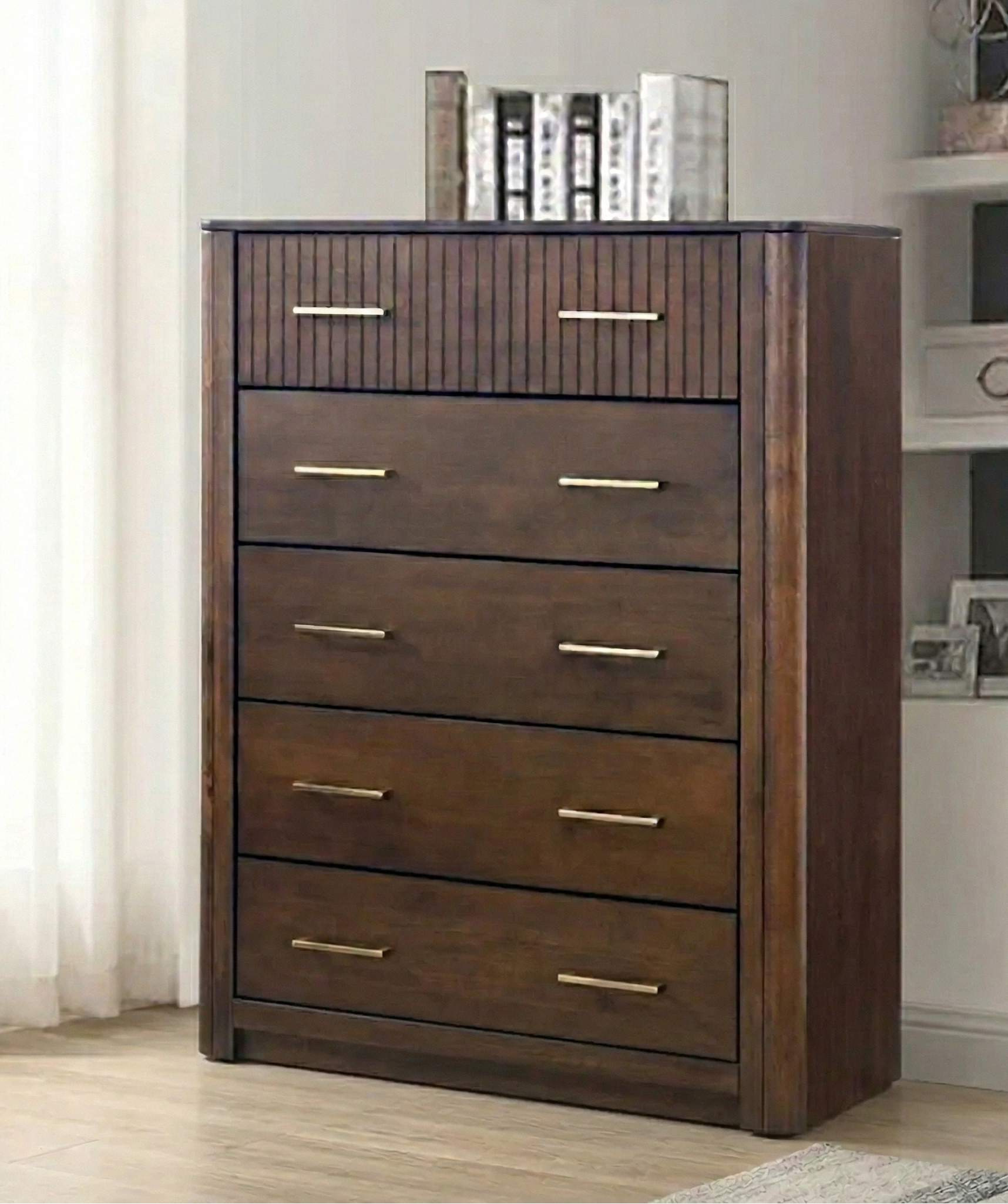 Wooden tallboy with five drawers in a room setting.
