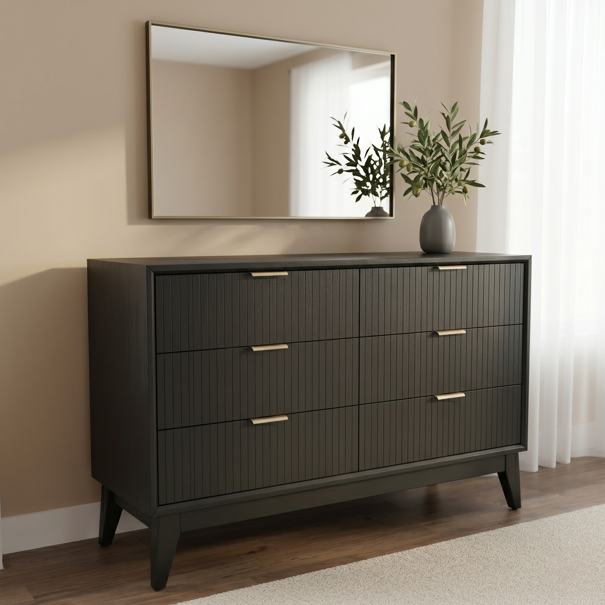 Dark wood dresser with gold handles against a beige wall with a mirror and plant.