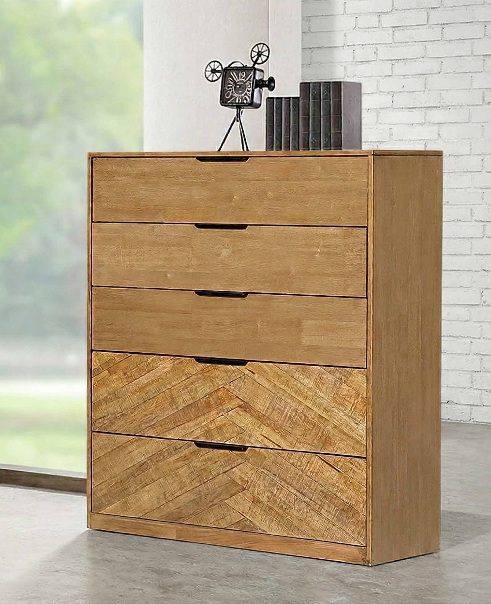 Wooden tallboy with five drawers in a room with a window and white brick wall.