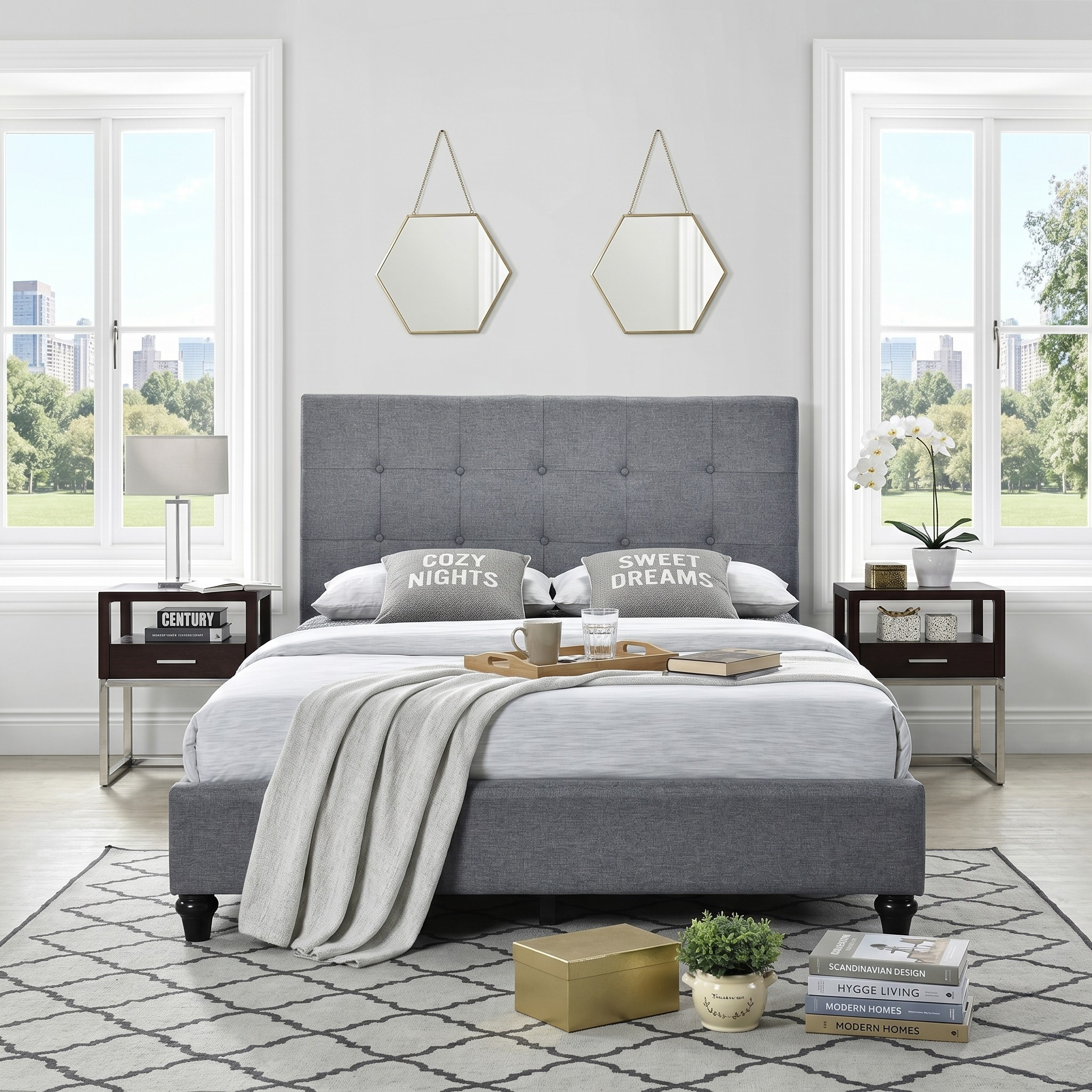Franco upholstered bed frame in gray with a tufted headboard, styled with cozy pillows, a soft blanket, two nightstands, decorative mirrors, and a patterned rug in a bright bedroom.