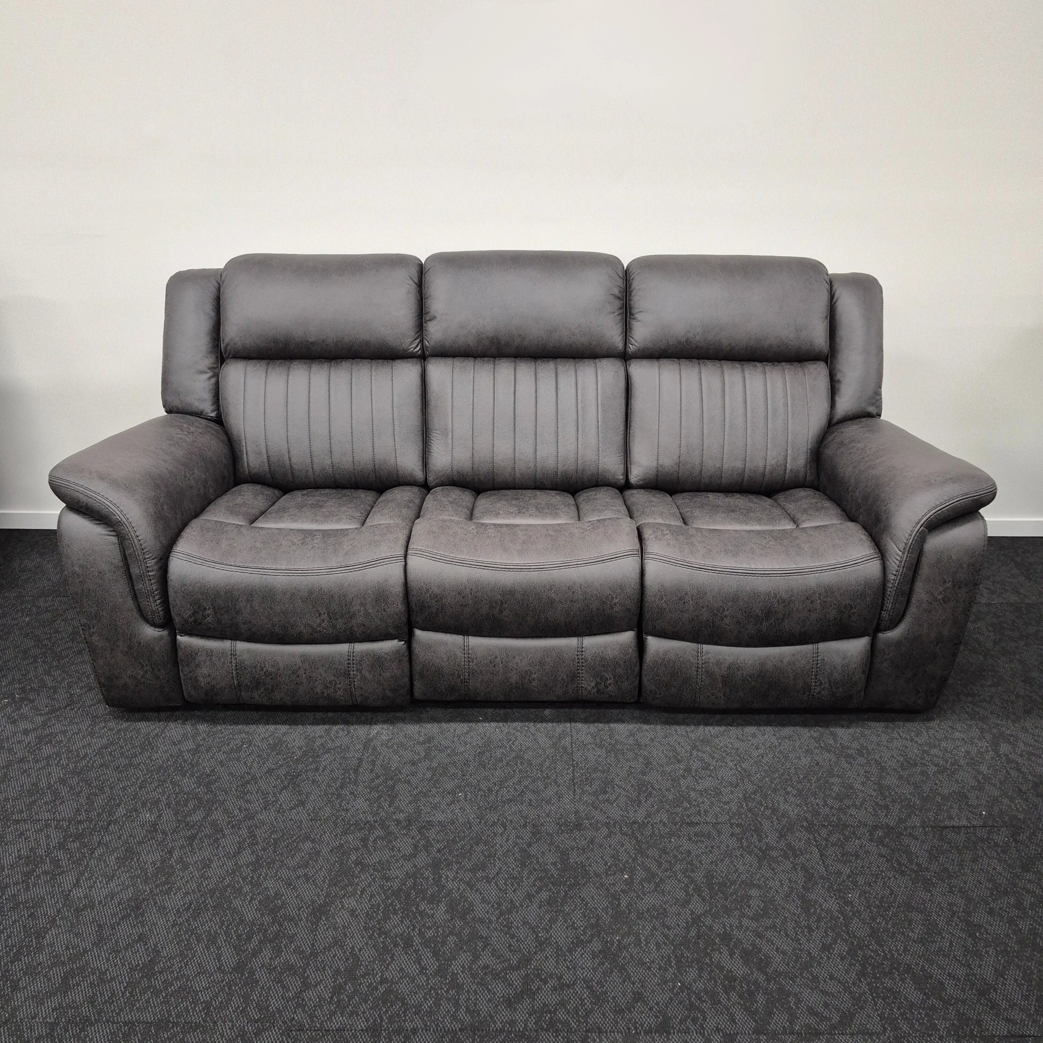 Grey three-seater recliner lounge sofa with cushioned arms and modern stitching detail