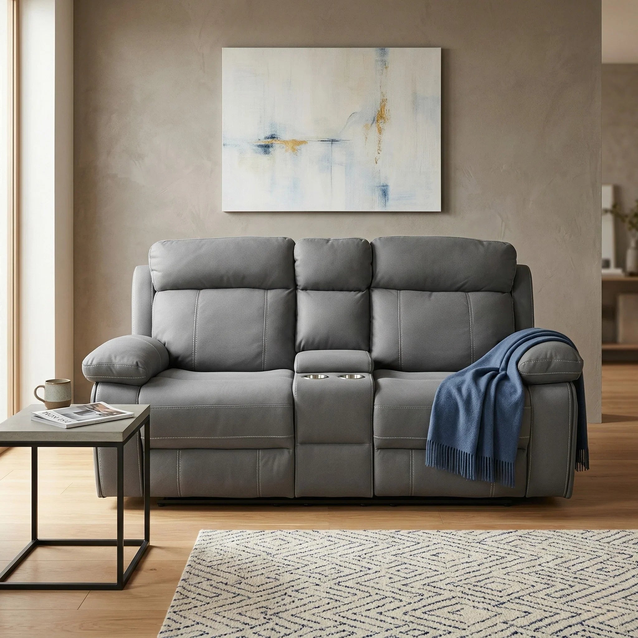 Gray sofa in a living room with a abstract painting on the wall.