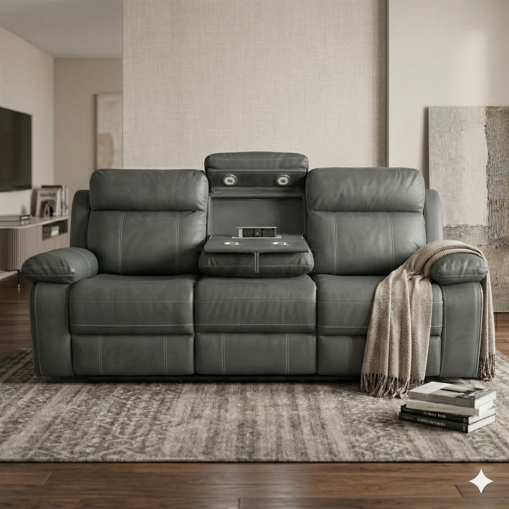 Gray leather reclining sofa in a living room setting with a blanket and books on a small table.