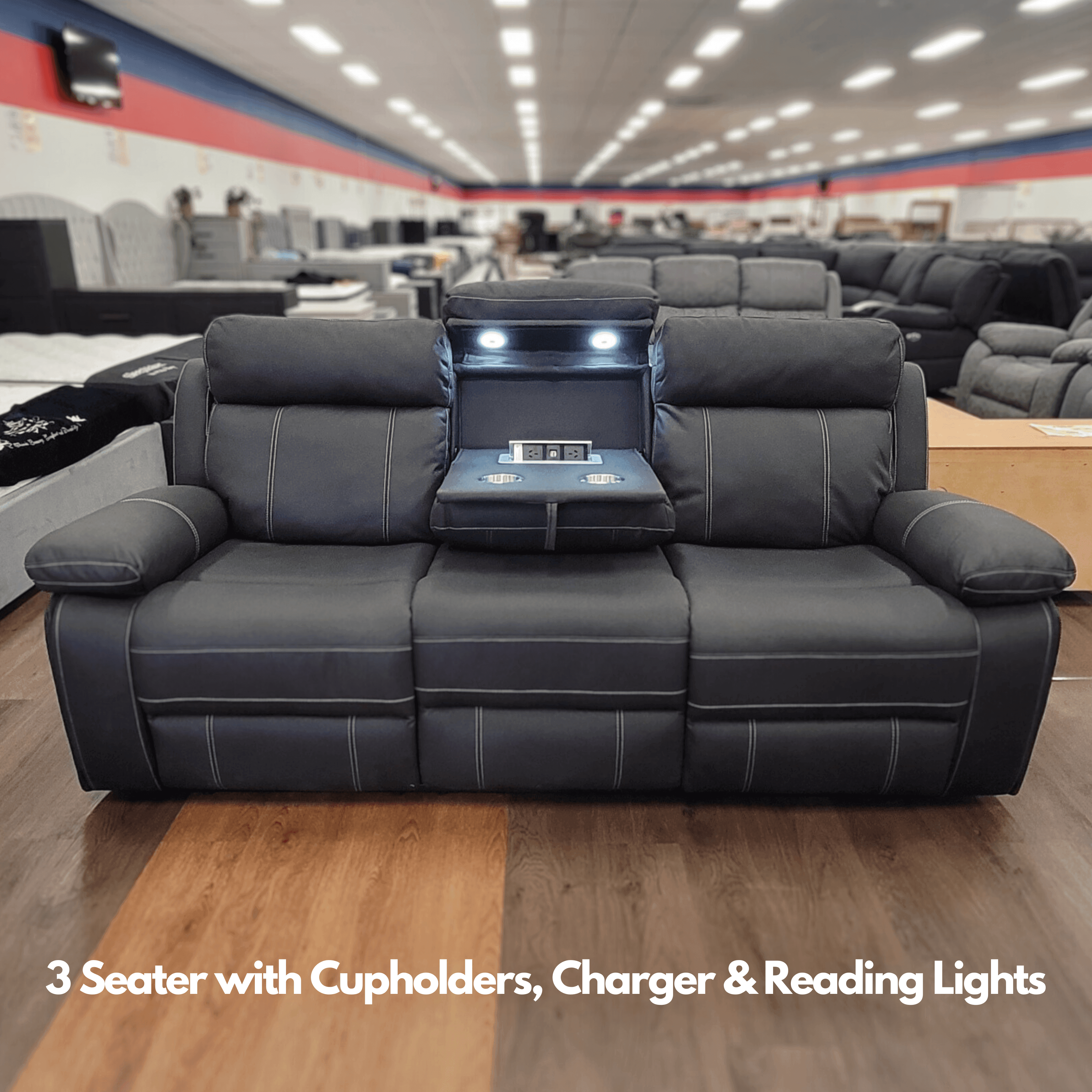 Black 3 seater recliner sofa with cupholders, USB charger, and reading lights in showroom