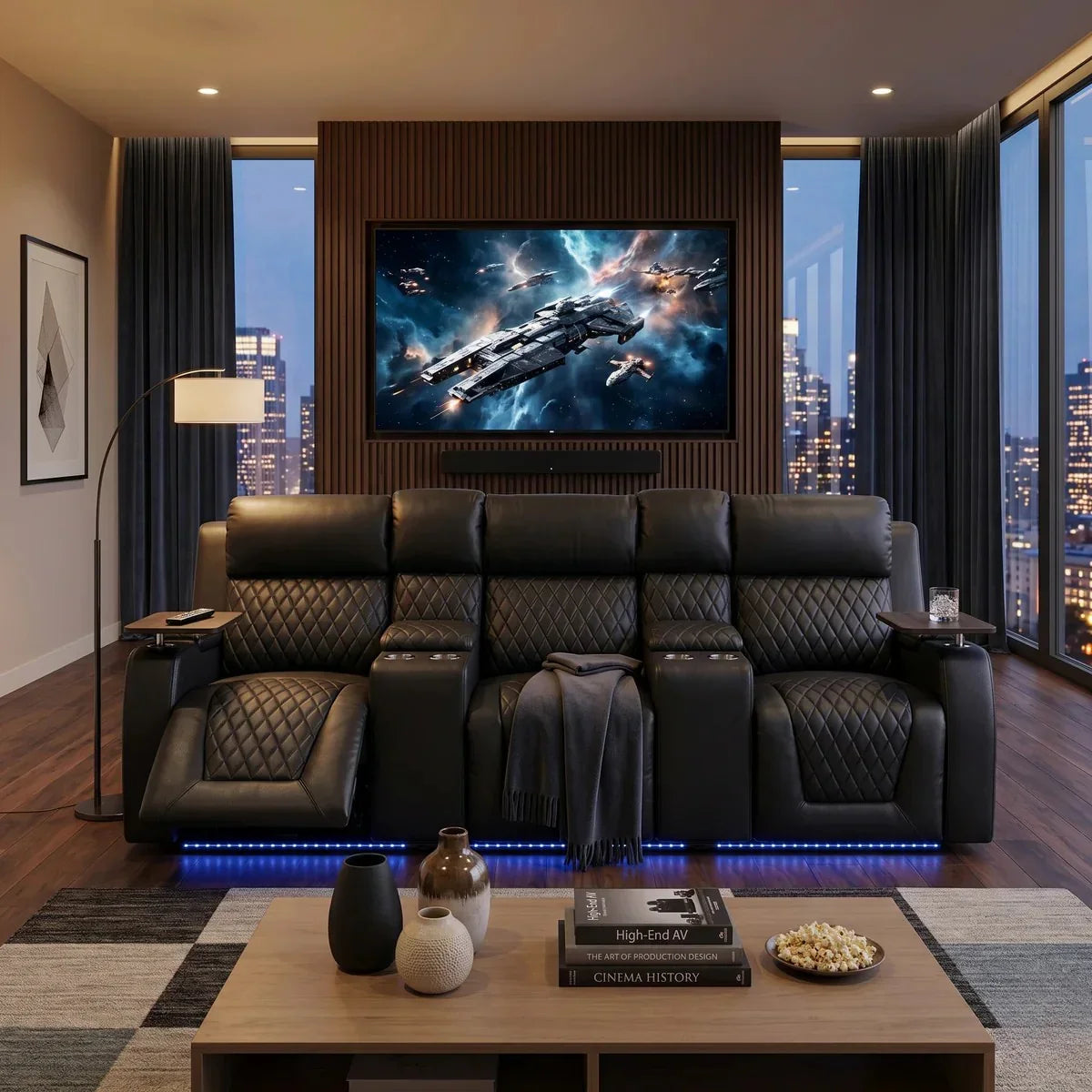 Blair 3-Seat Theatre Electric Recliner Lounge in black leather with quilted detailing shown in a modern living room setting with cityscape views and ambient lighting.