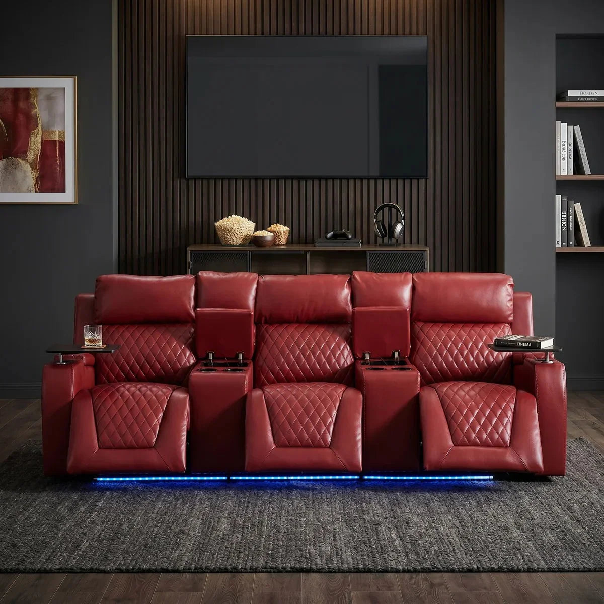 Blair 3-Seat Theatre Electric Recliner Lounge in rich red leather with quilted detailing, featuring three reclining seats, cup holders, and under-seat blue LED lighting in a modern living room.