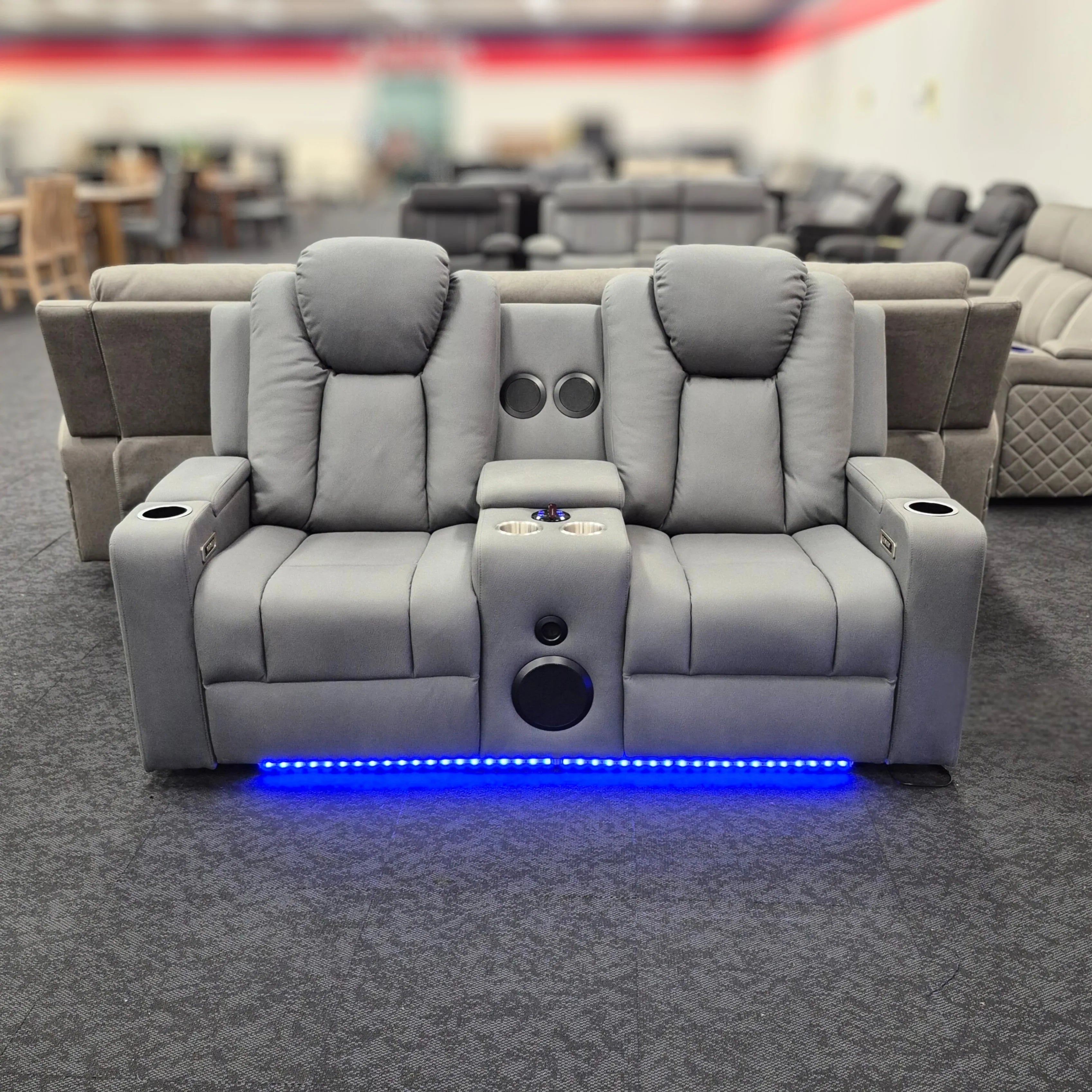 Grey 2 seater electric recliner lounge with cup holders, speakers, and blue LED lights