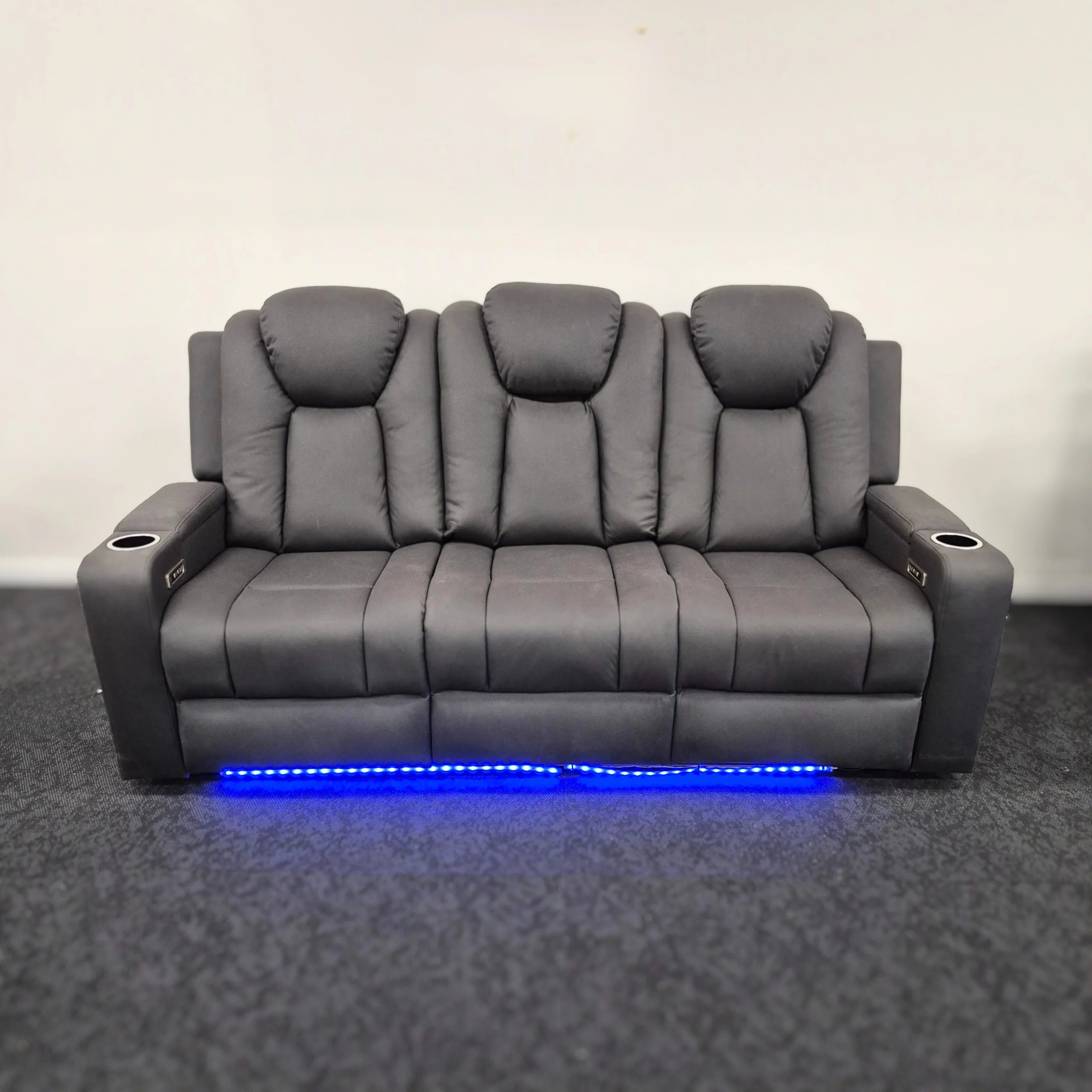 Modern grey 3-seater electric recliner lounge with cup holders and blue LED lighting.