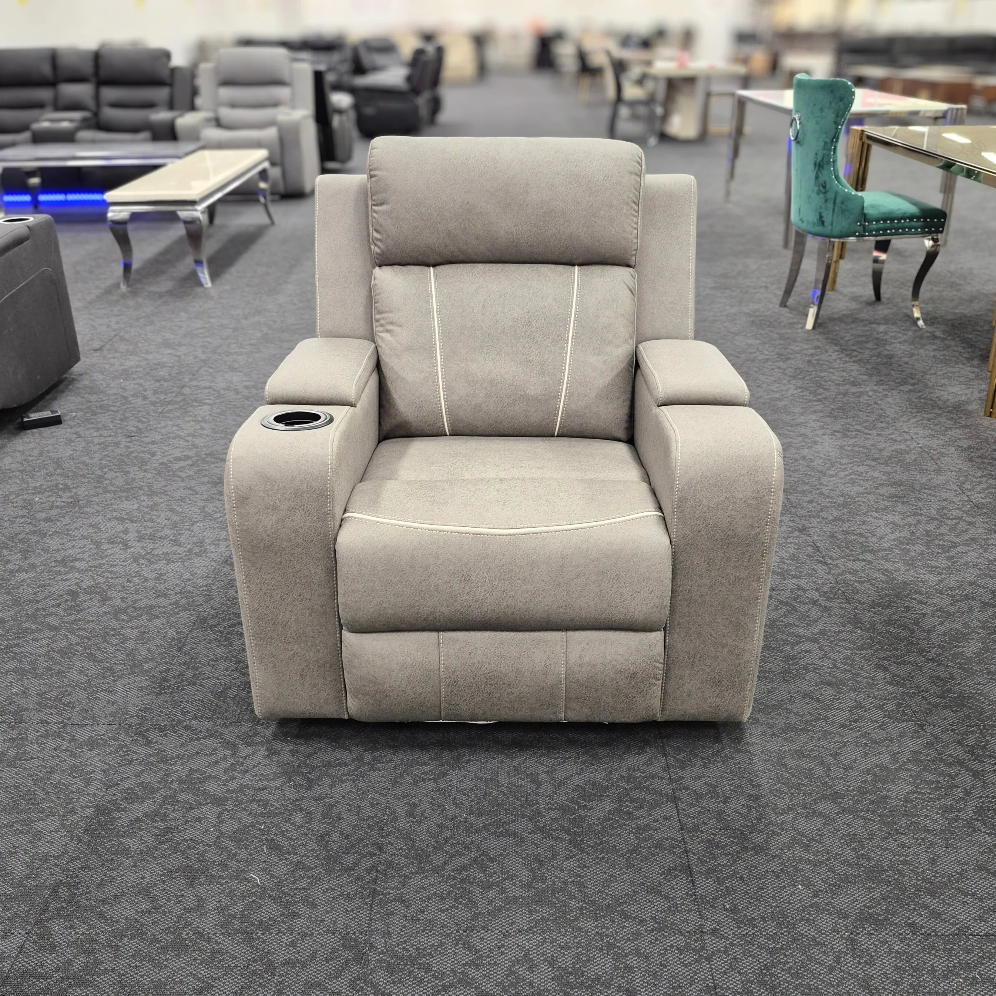 Grey recliner chair with cup holder, modern lounge furniture in showroom setting