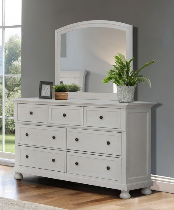White dresser with mirror and decorative plants in a room with a window and gray wall.