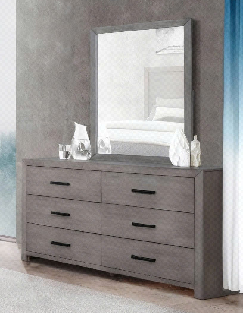 Gray dresser with a large mirror on a gray wall.
