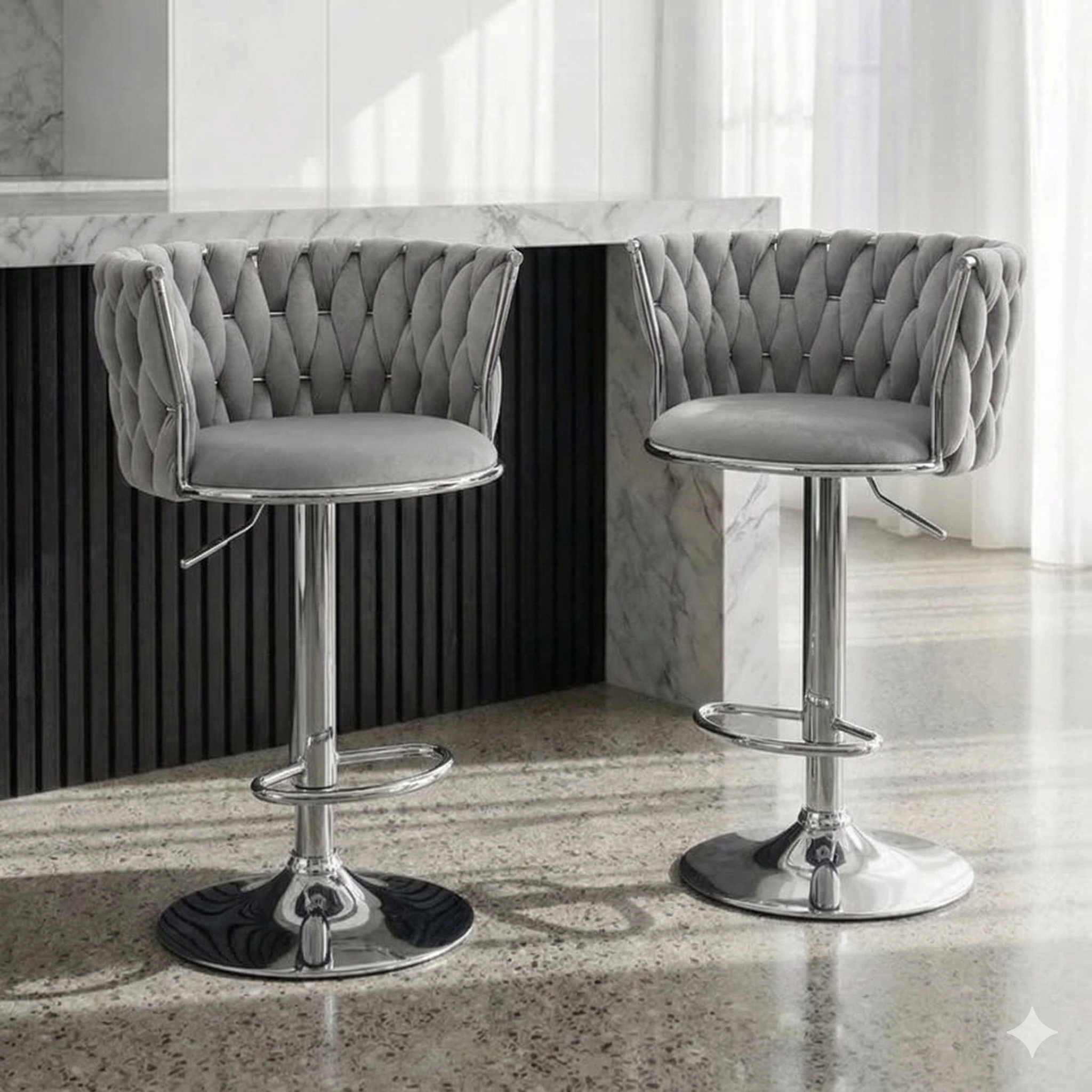 Two gray tufted bar stools with chrome bases in a modern kitchen setting.