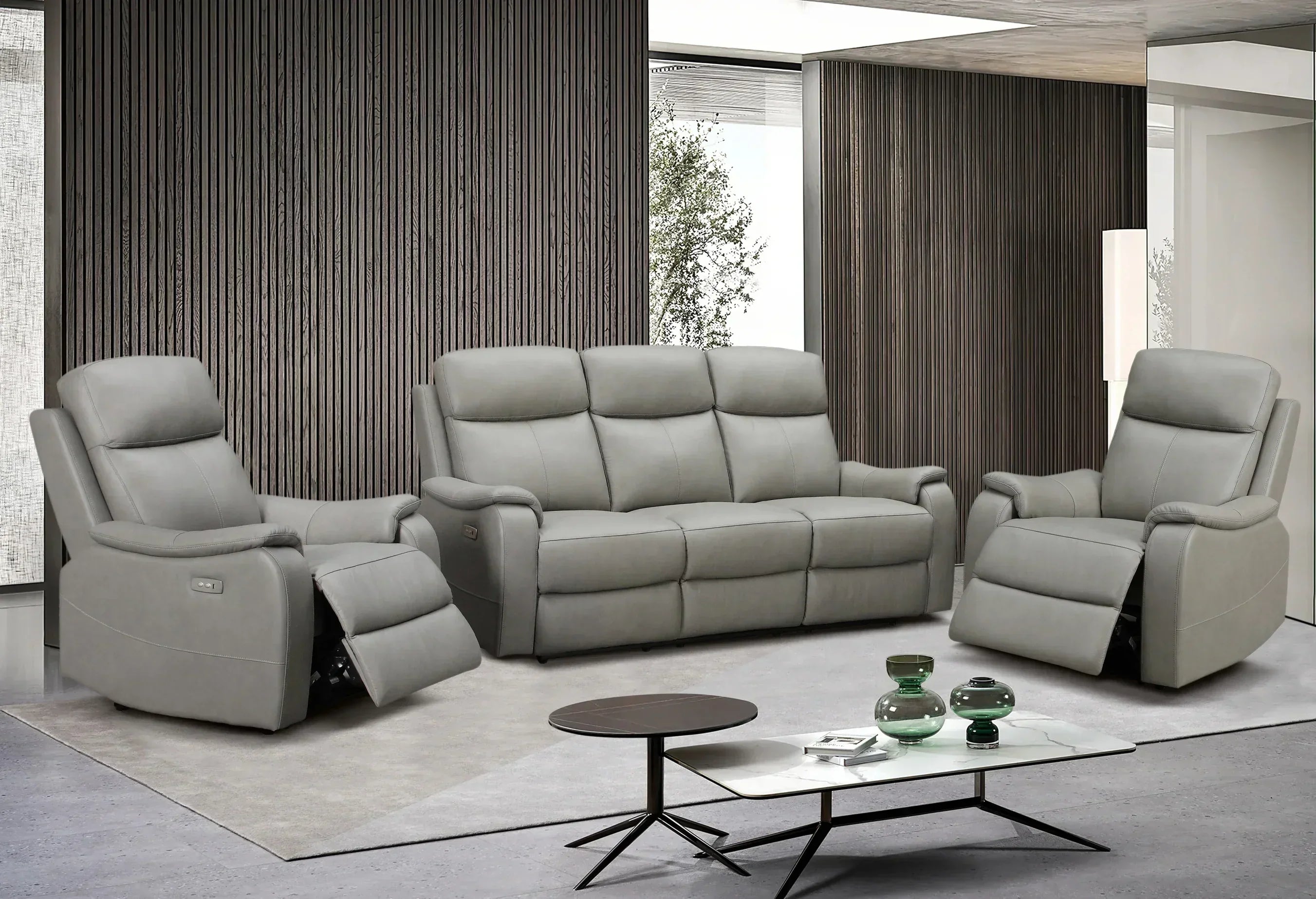 Gray reclining sofa set in a modern living room with a coffee table and decorative items.