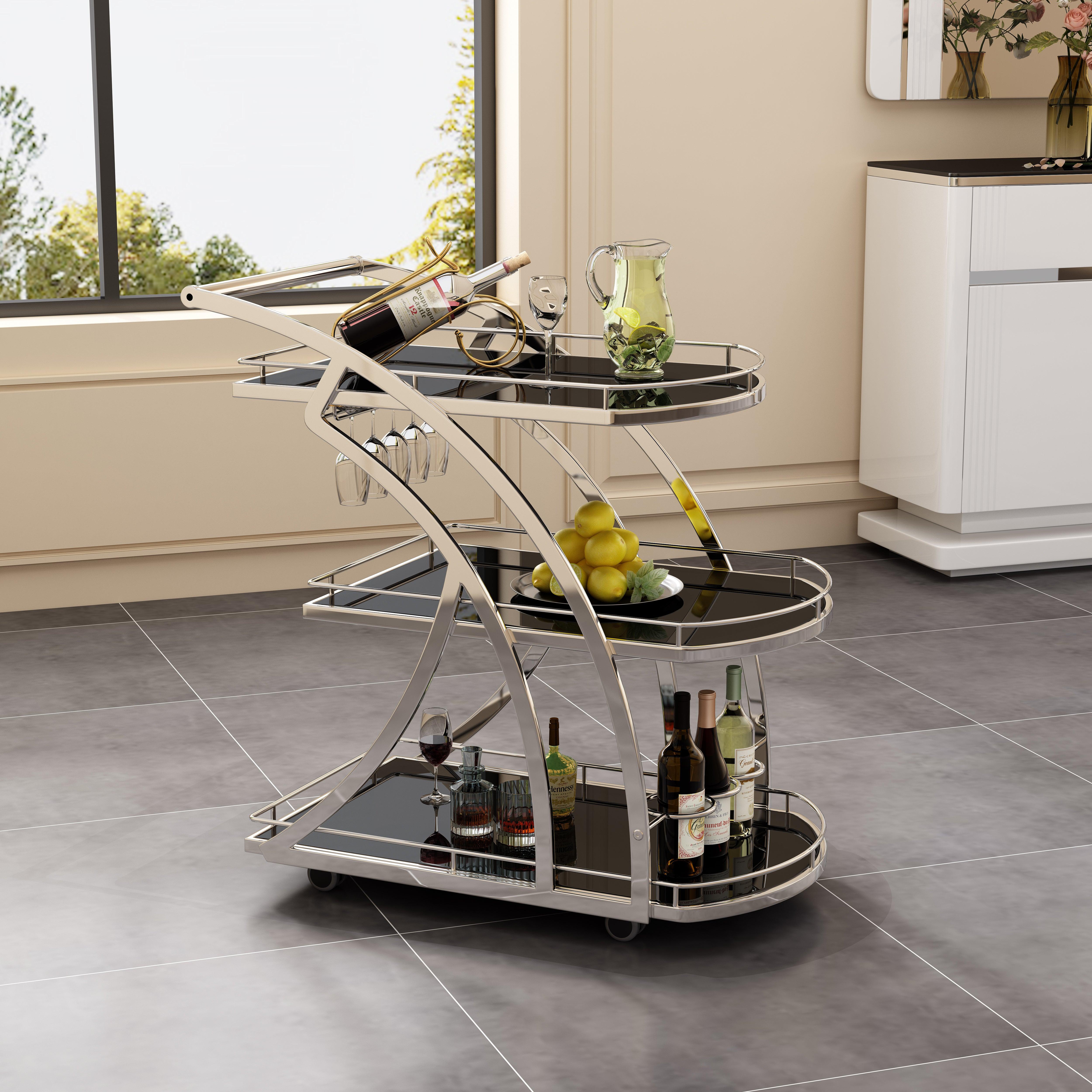 Modern three-tier black glass bar cart with chrome frame, wine bottles, glasses, and fruit on wheels in a stylish living space.