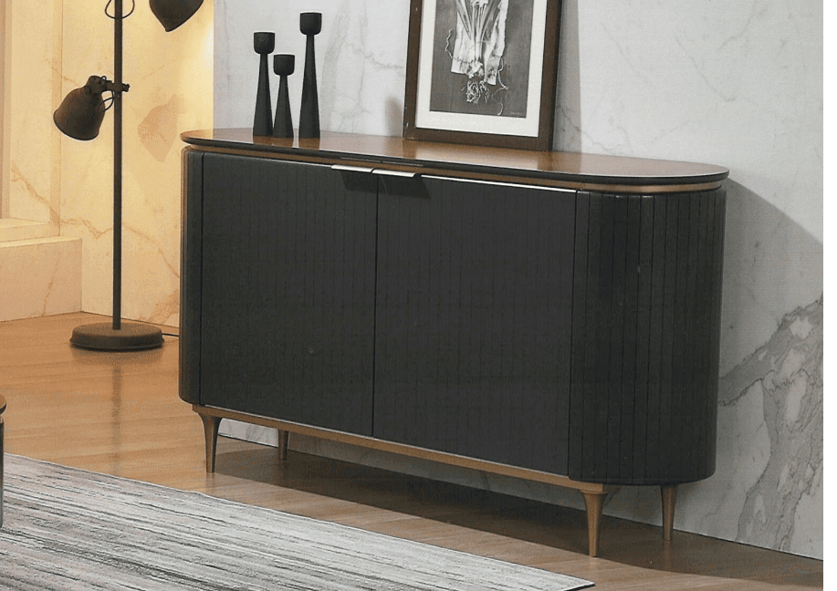 Black sideboard in a room with a lamp and framed picture on a marble wall.