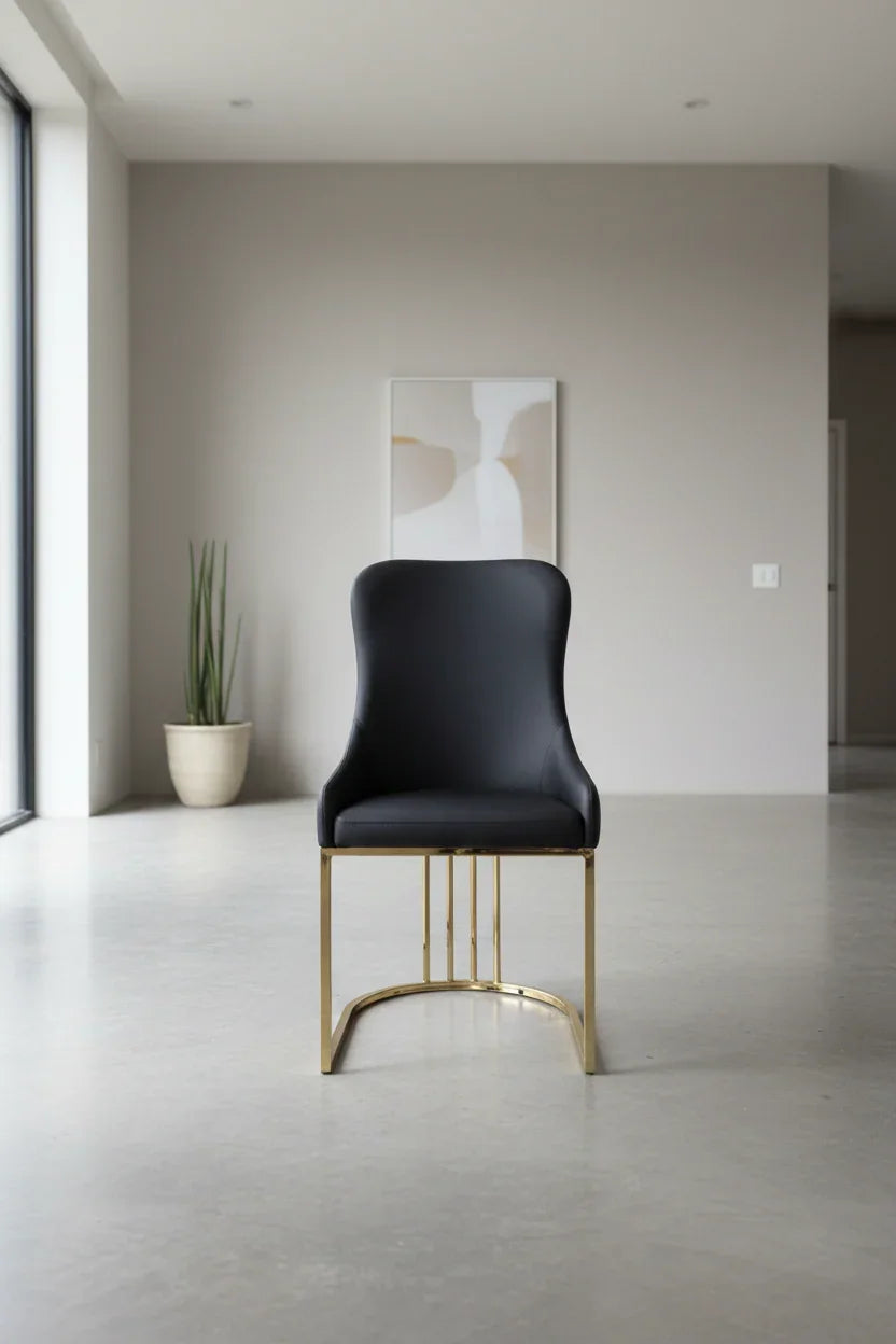 Modern black leather chair with gold legs in a minimalistic room.
