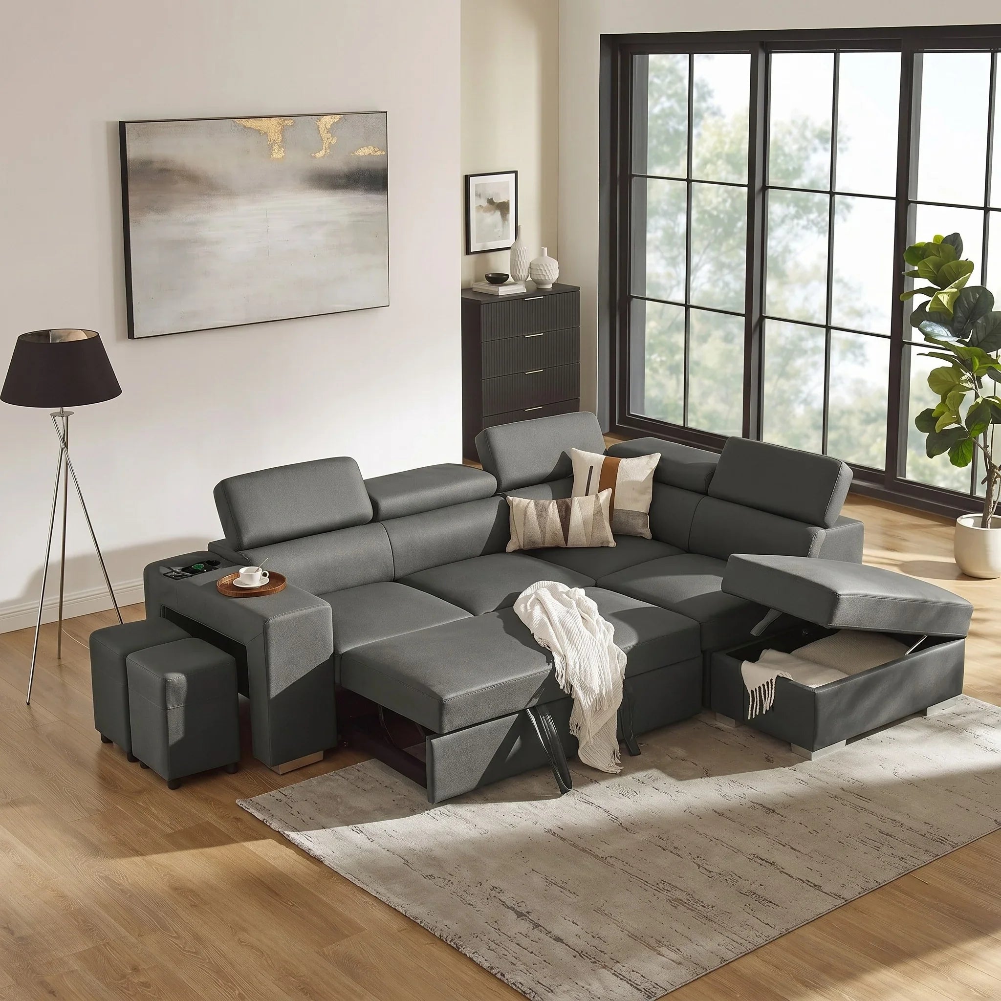 Gray sectional sofa bed in a living room with a rug, lamp, and window.