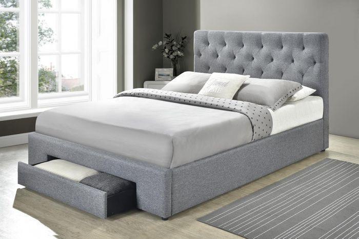Modern grey upholstered bed with tufted headboard and storage drawer in bright bedroom