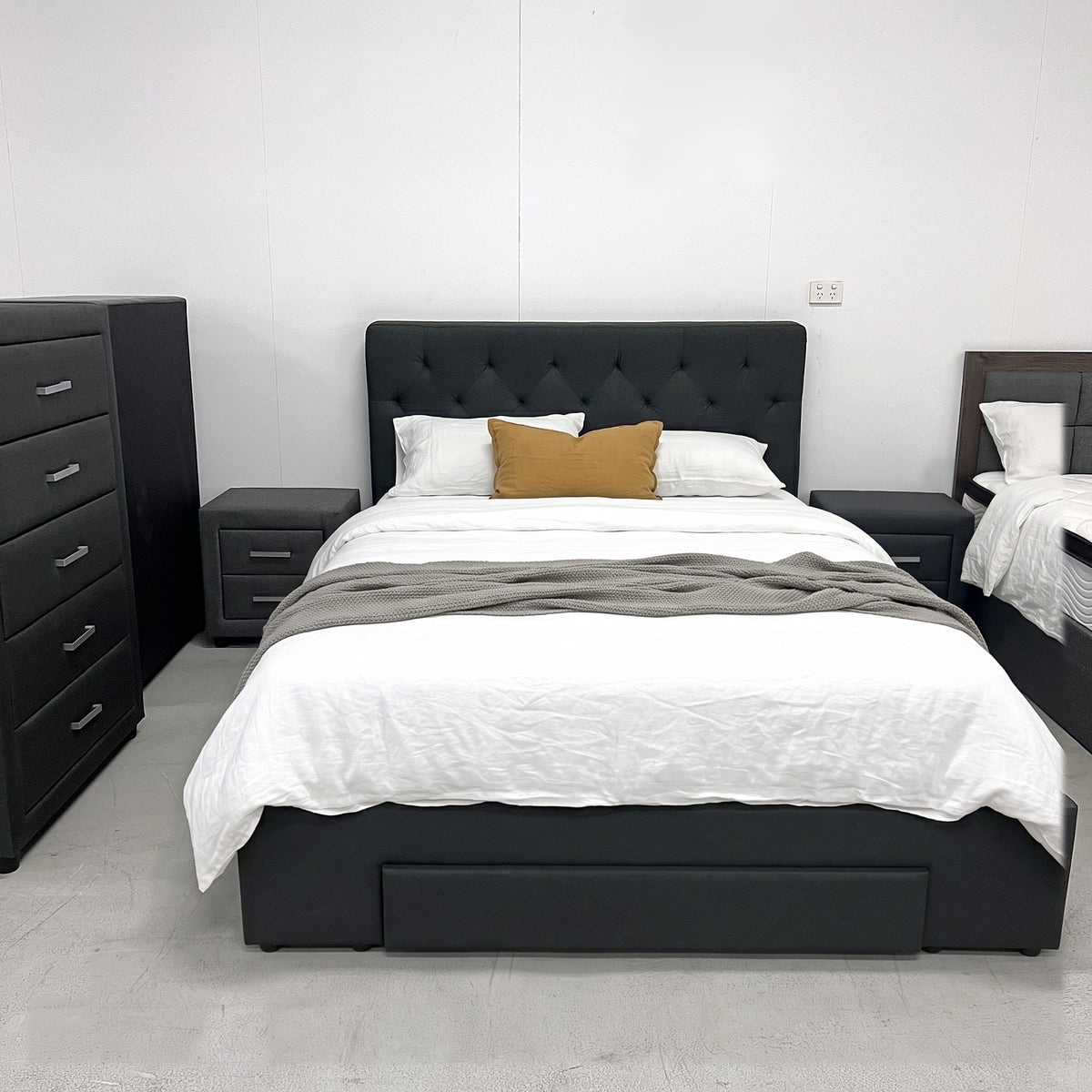 Fabulous storage bed frame in Black Grey fabric with button-tufted headboard, styled in our showroom