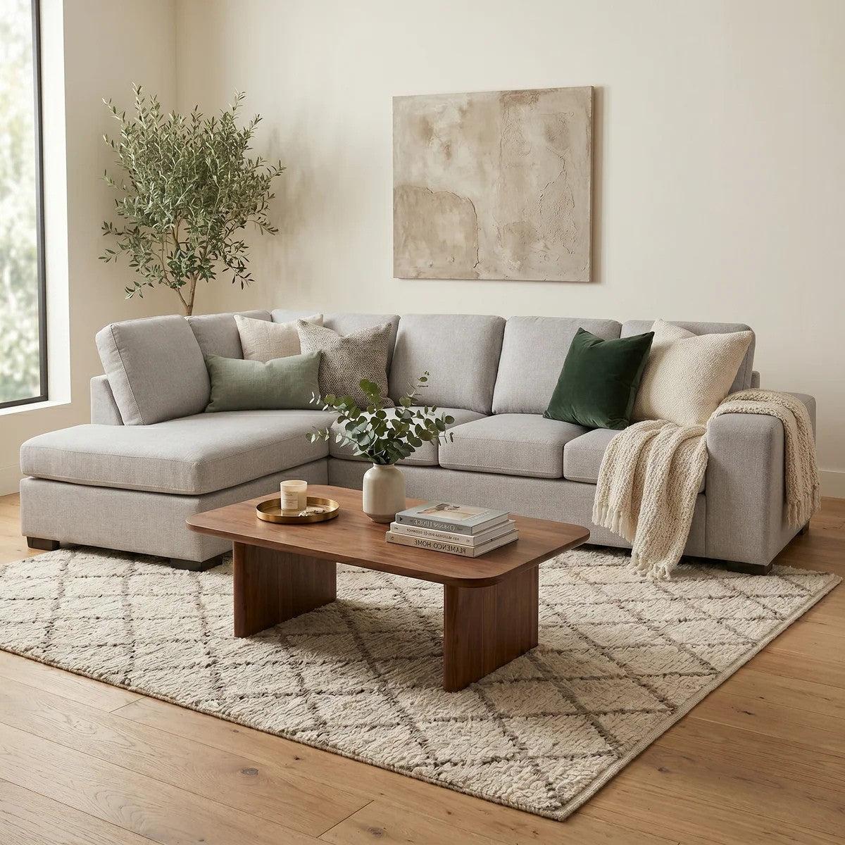 Fairfield Corner Sofa in light gray fabric with plush cushions, styled with green and beige pillows, a cream throw, and a wooden coffee table on a patterned rug in a bright living room.