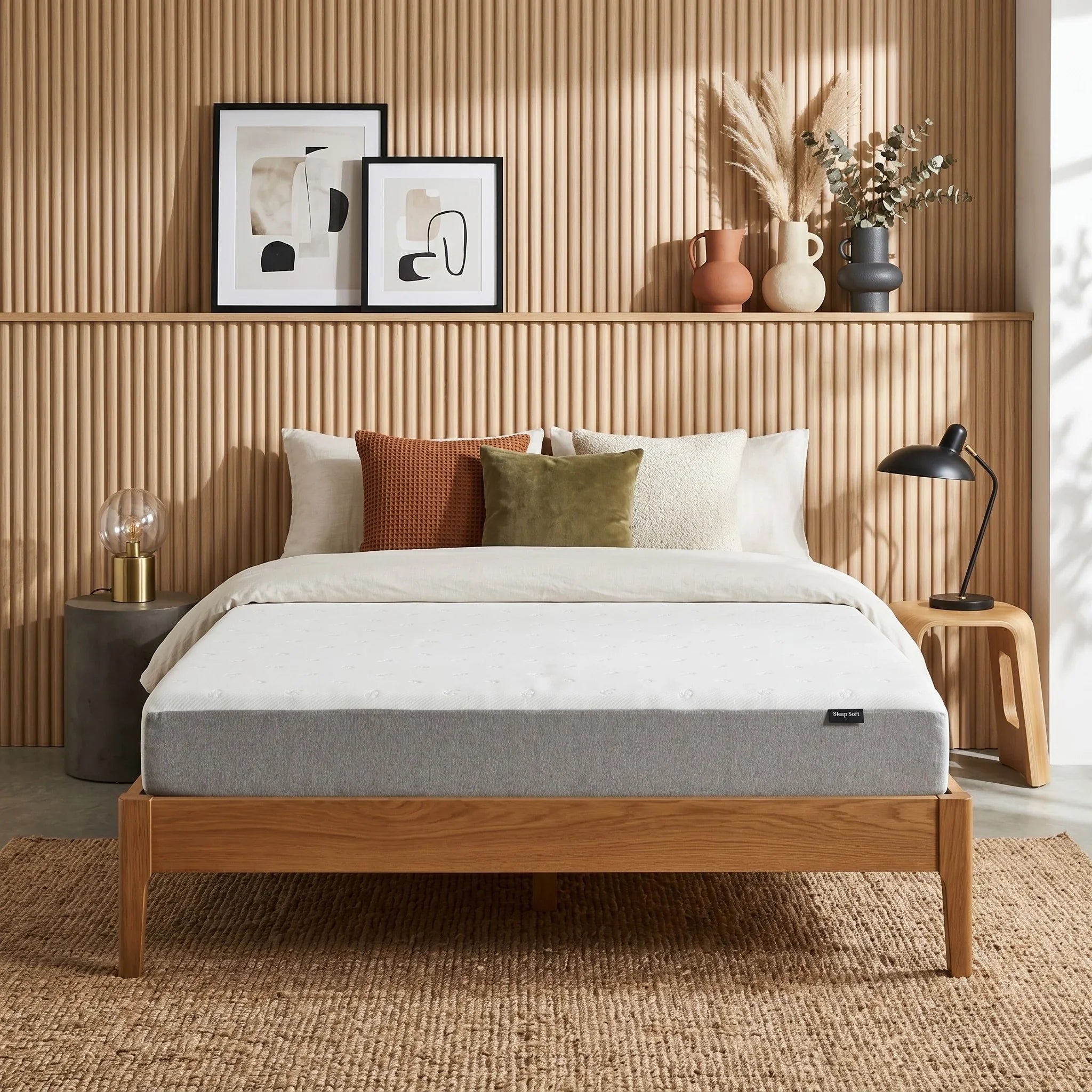 Bedroom with a wooden bed frame, white mattress, and decorative pillows against a wooden wall.