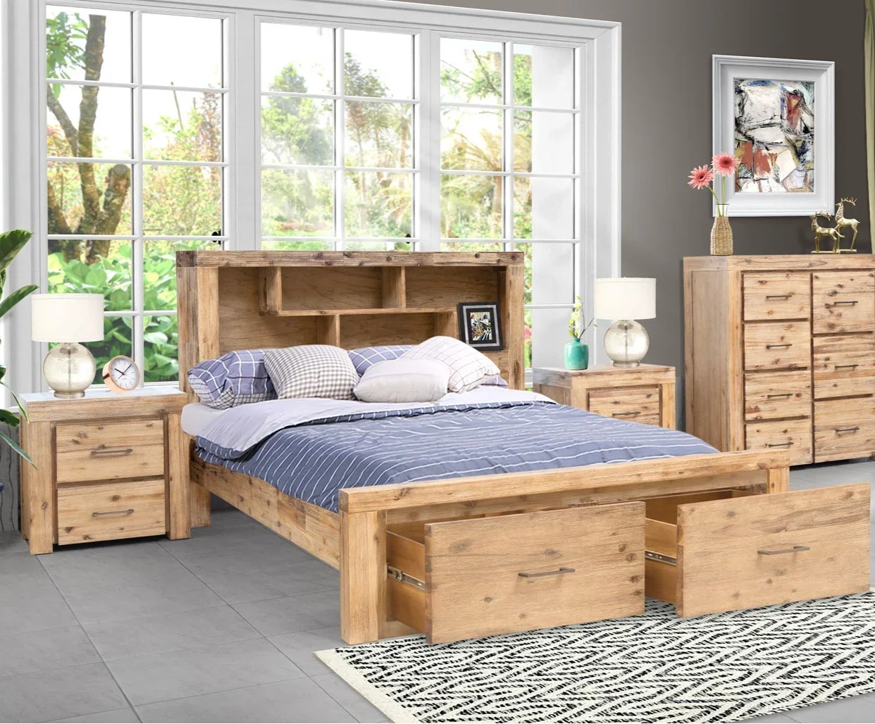 Wooden bedroom set with bed, dressers, and nightstands in a room with large windows.