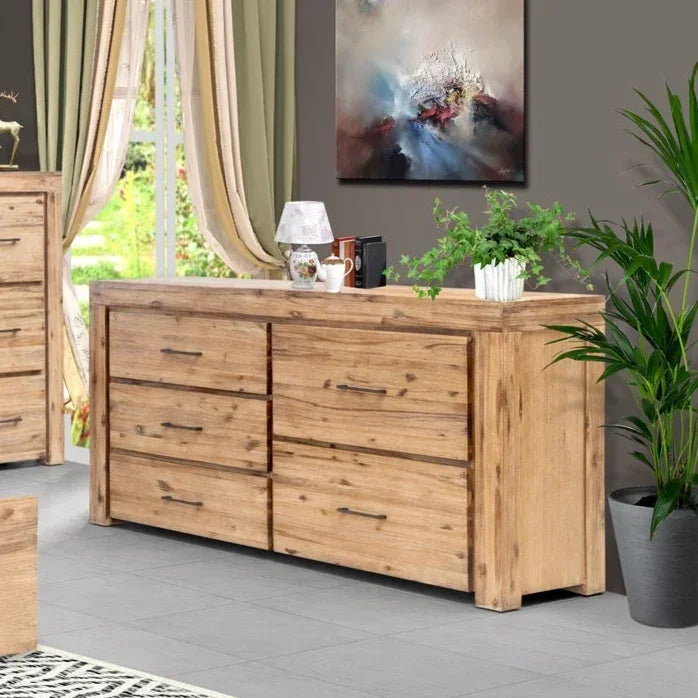 Wooden dresser in a room with a painting and plants