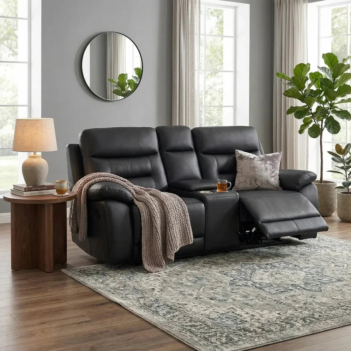 Black leather recliner sofa in a living room with a side table, lamp, and plants.
