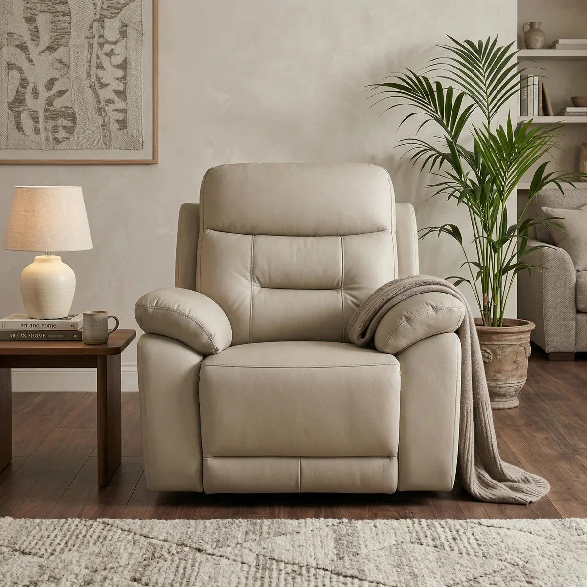 Beige recliner chair in a living room setting with a side table, lamp, and plant.