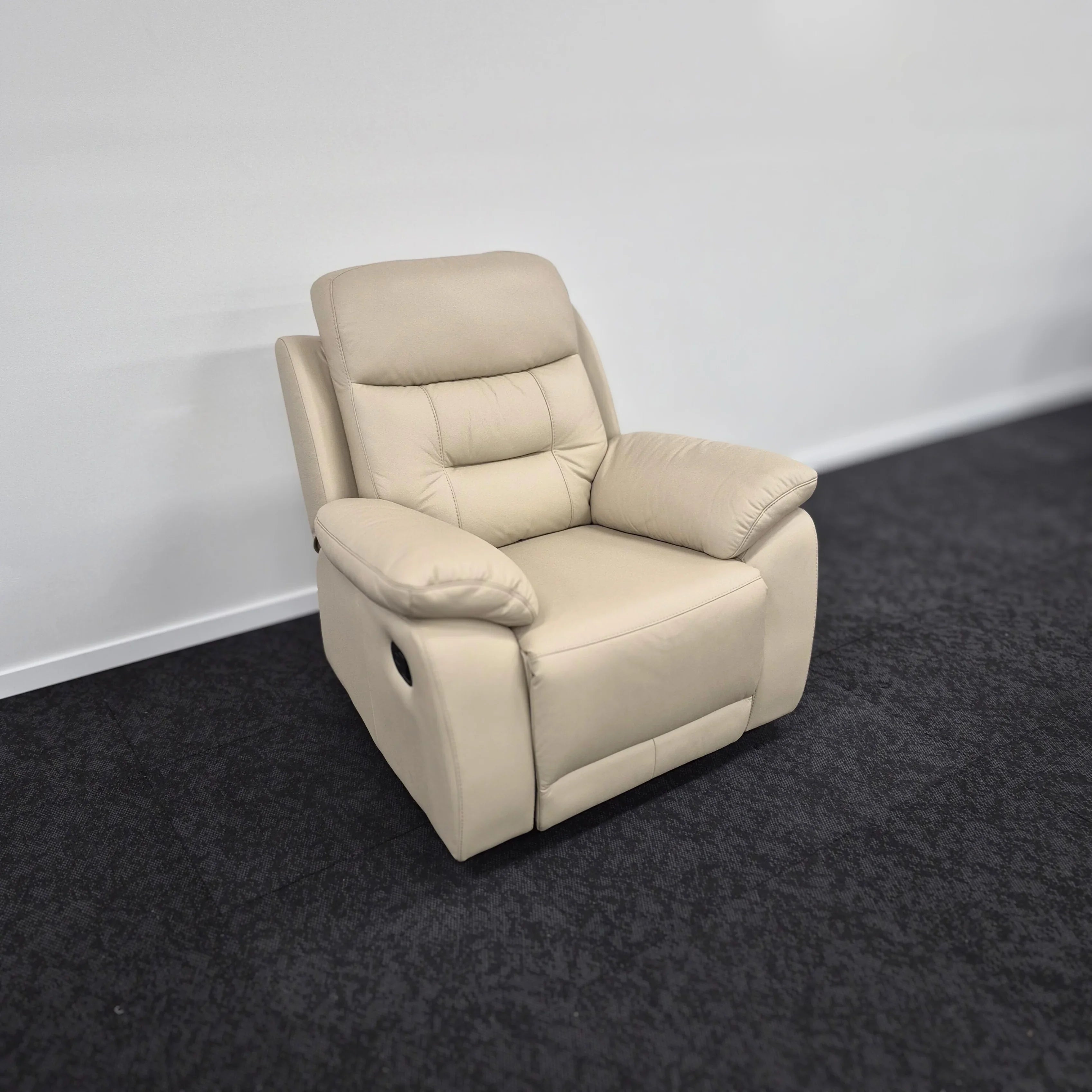 Beige leather recliner chair with plush cushions in a modern lounge setting