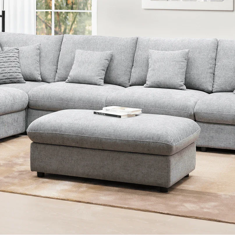 Gray sectional sofa with ottoman in a living room setting