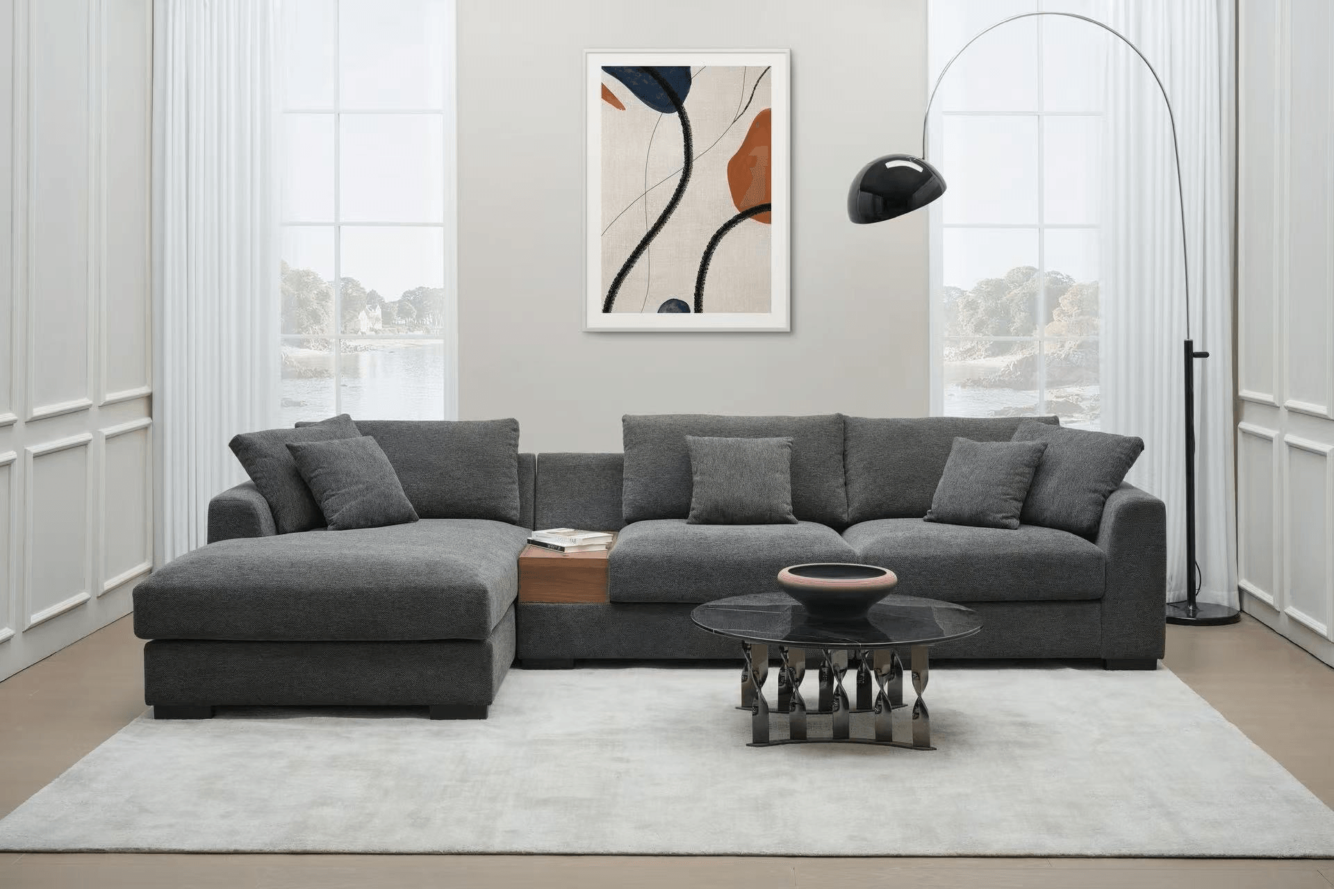 Modern living room with grey sectional sofa, glass coffee table, floor lamp, and wall art