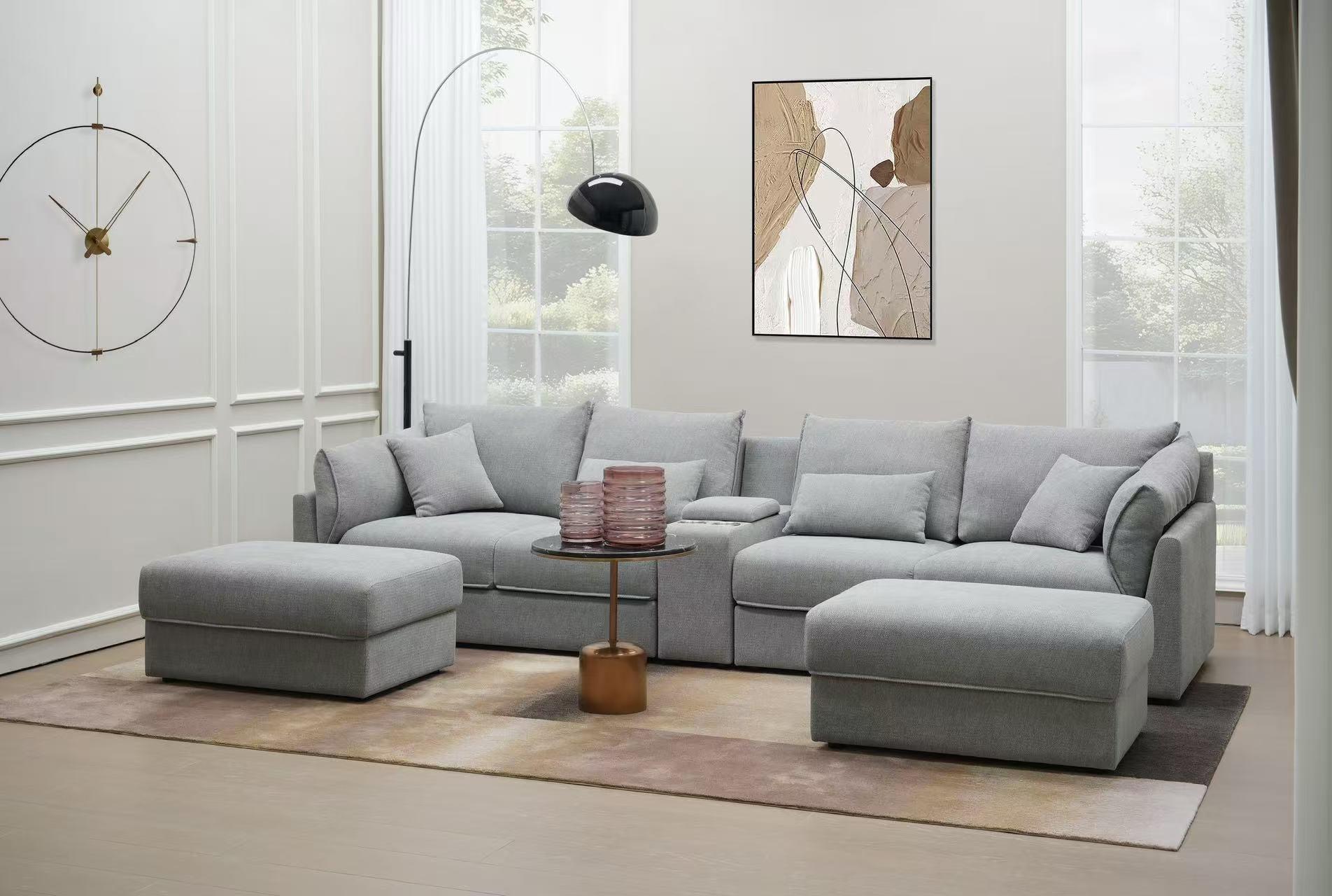 Modern living room with grey sectional sofa, ottoman, and abstract wall art