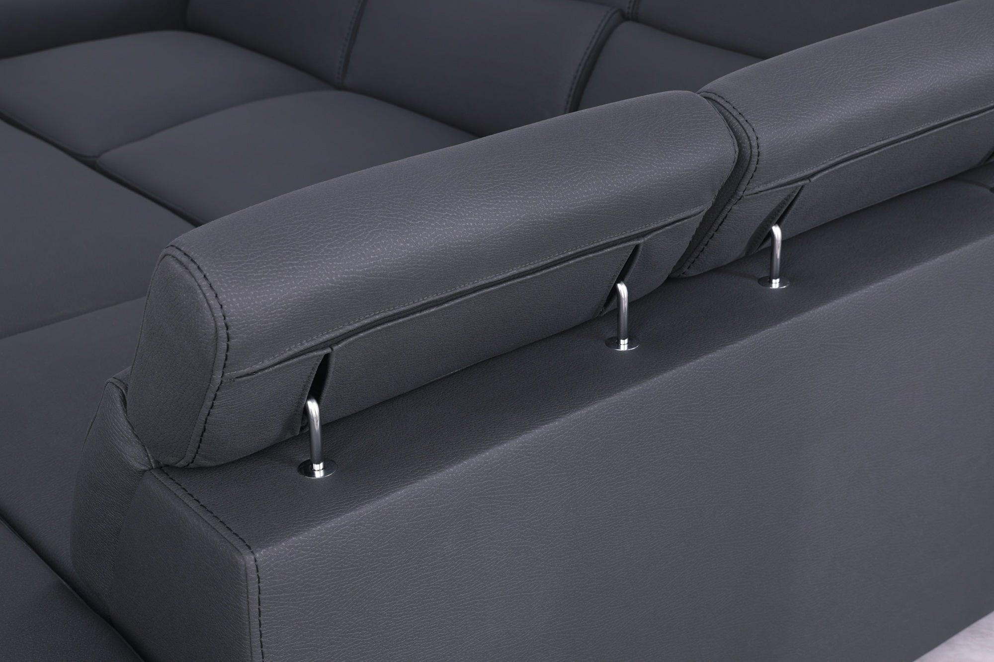 Close-up of dark grey adjustable headrest on modern leather sofa with chrome supports.