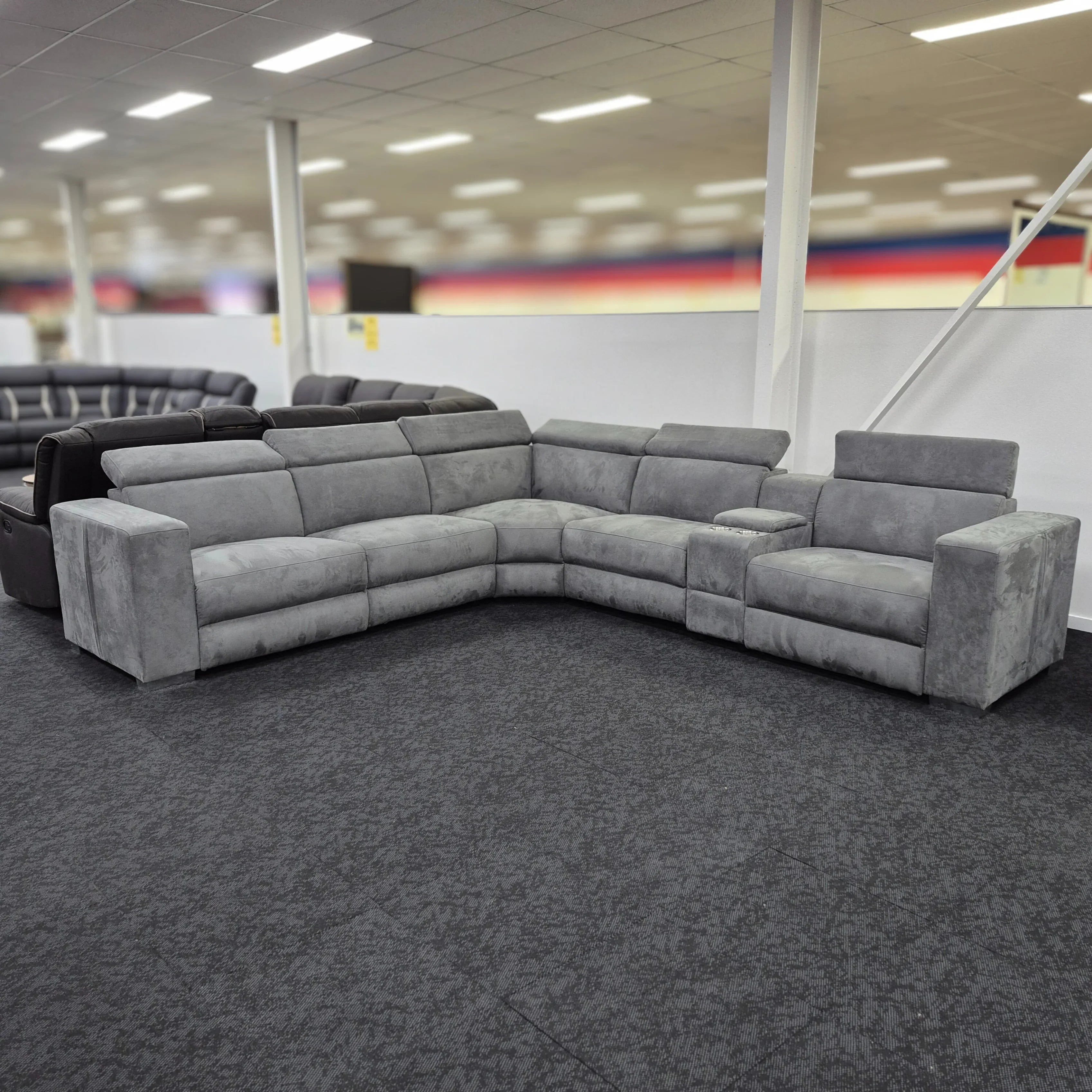 Gray sectional sofa in a showroom setting with blurred background
