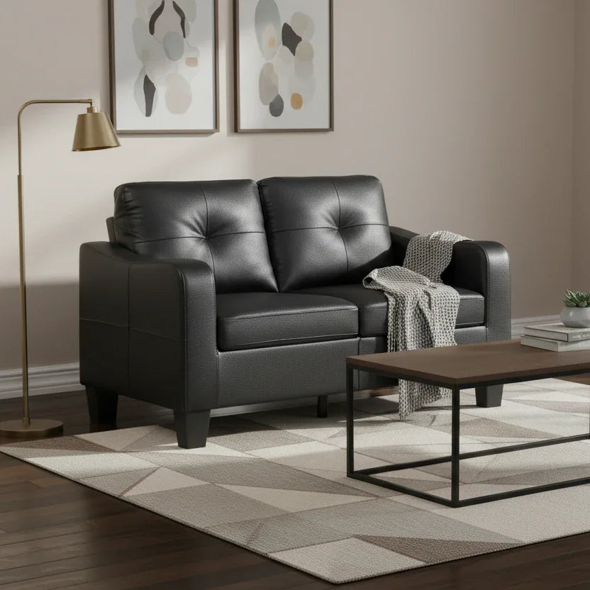 Modern living room with black leather sofa, wooden coffee table, and abstract art on the wall.