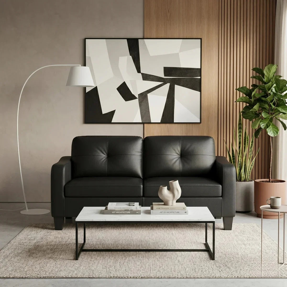 Modern living room with a black leather sofa, white coffee table, and abstract art on the wall.