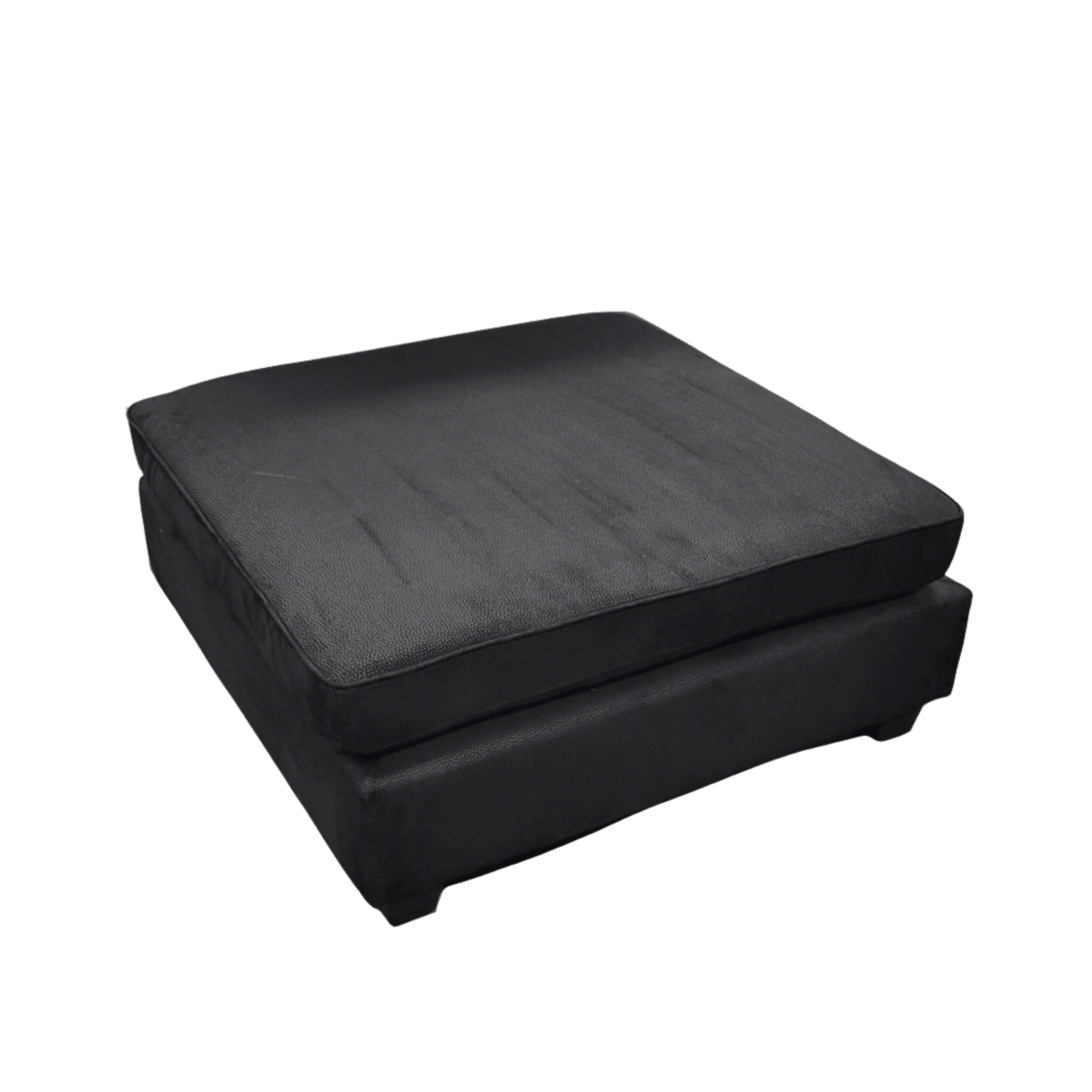 Black square ottoman with plush black fabric in a modern living room.