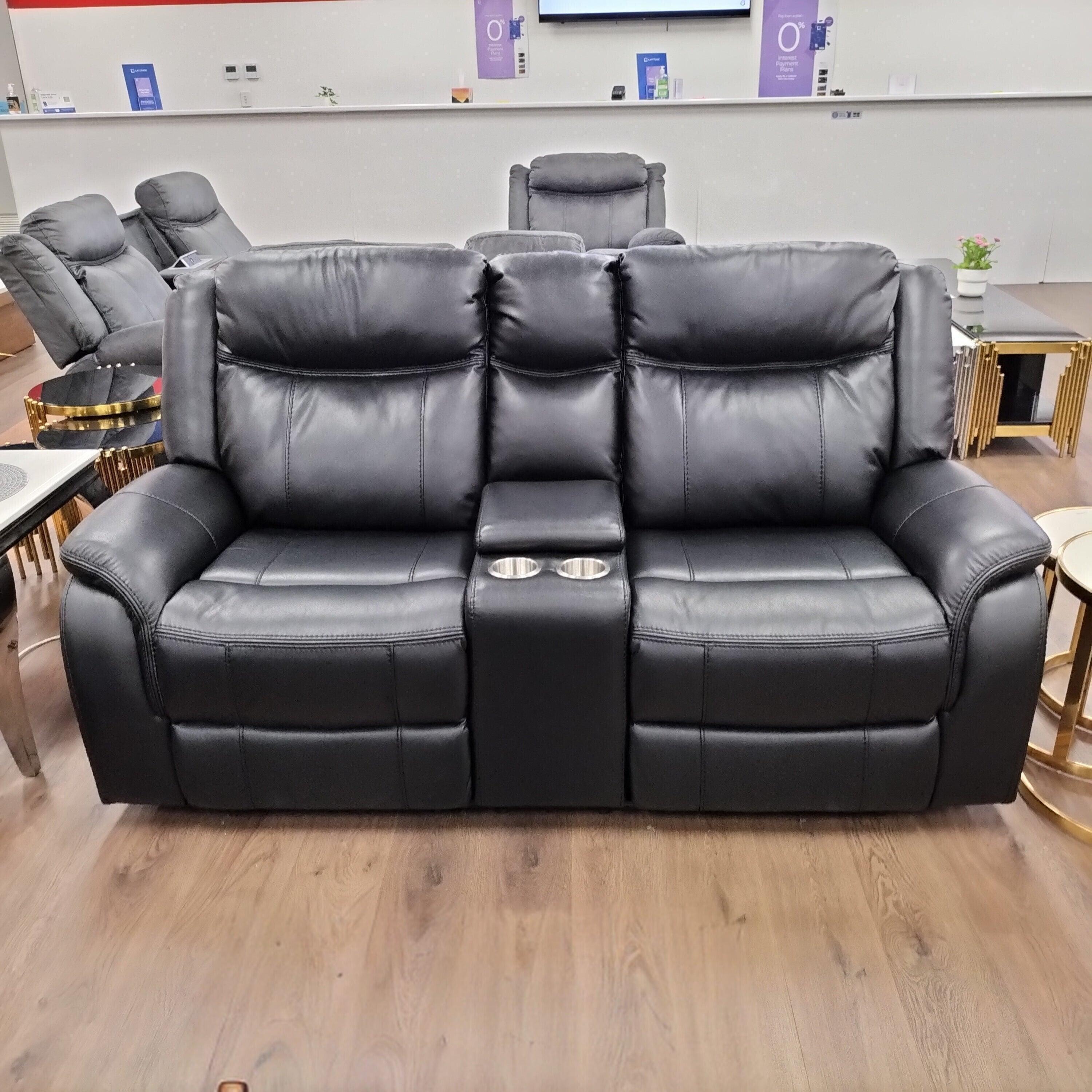 Black 2 seater air leather recliner lounge with cup holders in a modern living room