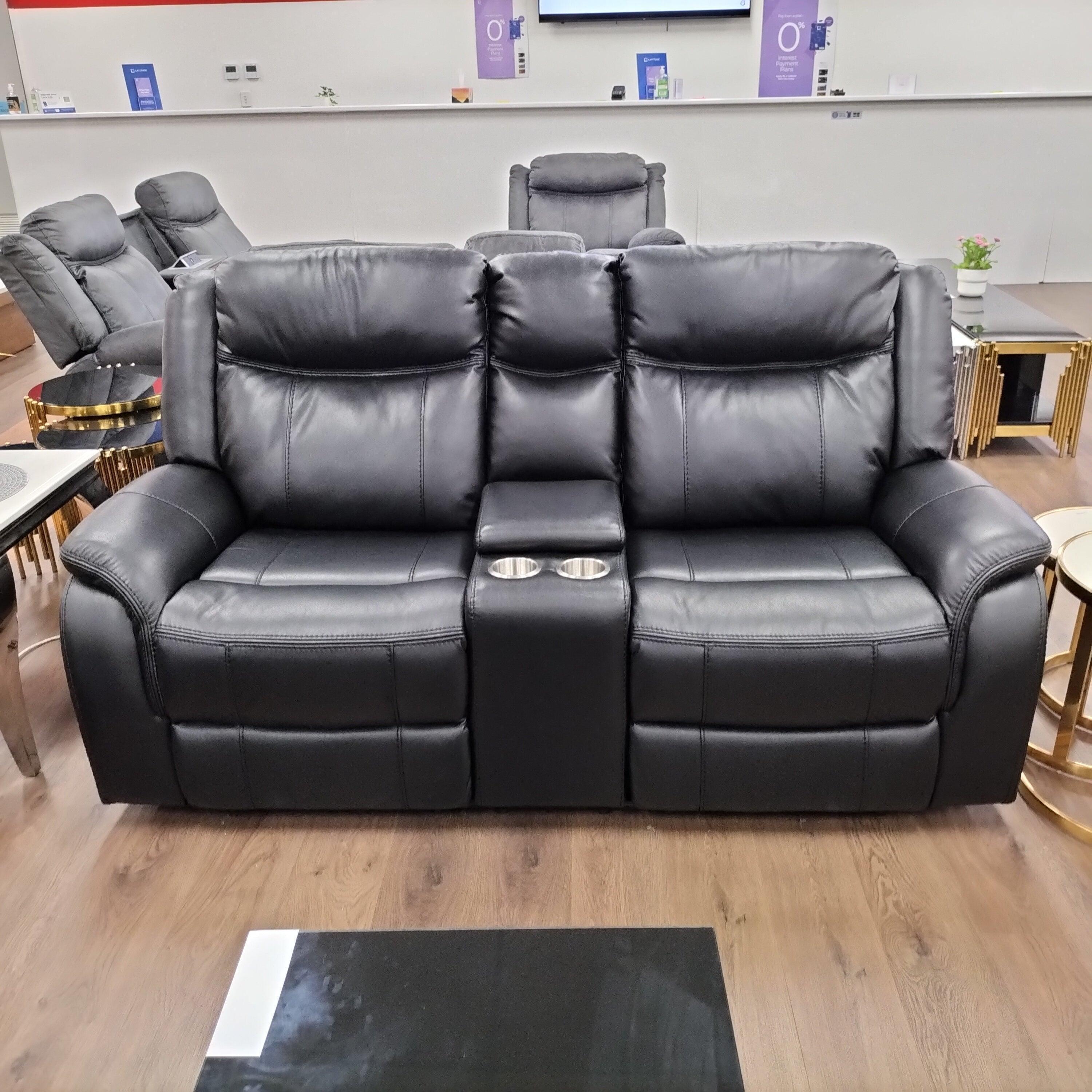 Black leather recliner sofa with cup holders in a modern living room showroom