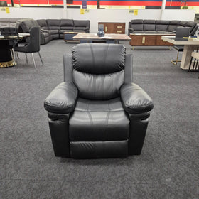 Black leather recliner armchair on showroom floor with modern lounge and dining furniture
