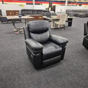 Black leather recliner armchair in a furniture showroom with sofas and dining tables